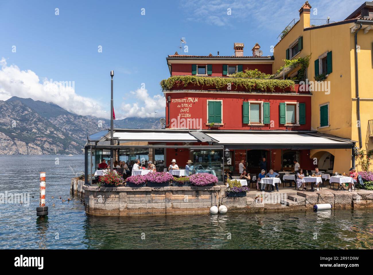 Le pittoresque port de Malcesine sur la Piazza Guglielmo Marconi qui est entouré de nombreux restaurants et cafés, Malcesine, Lac de Garde, Italie, Europe Banque D'Images