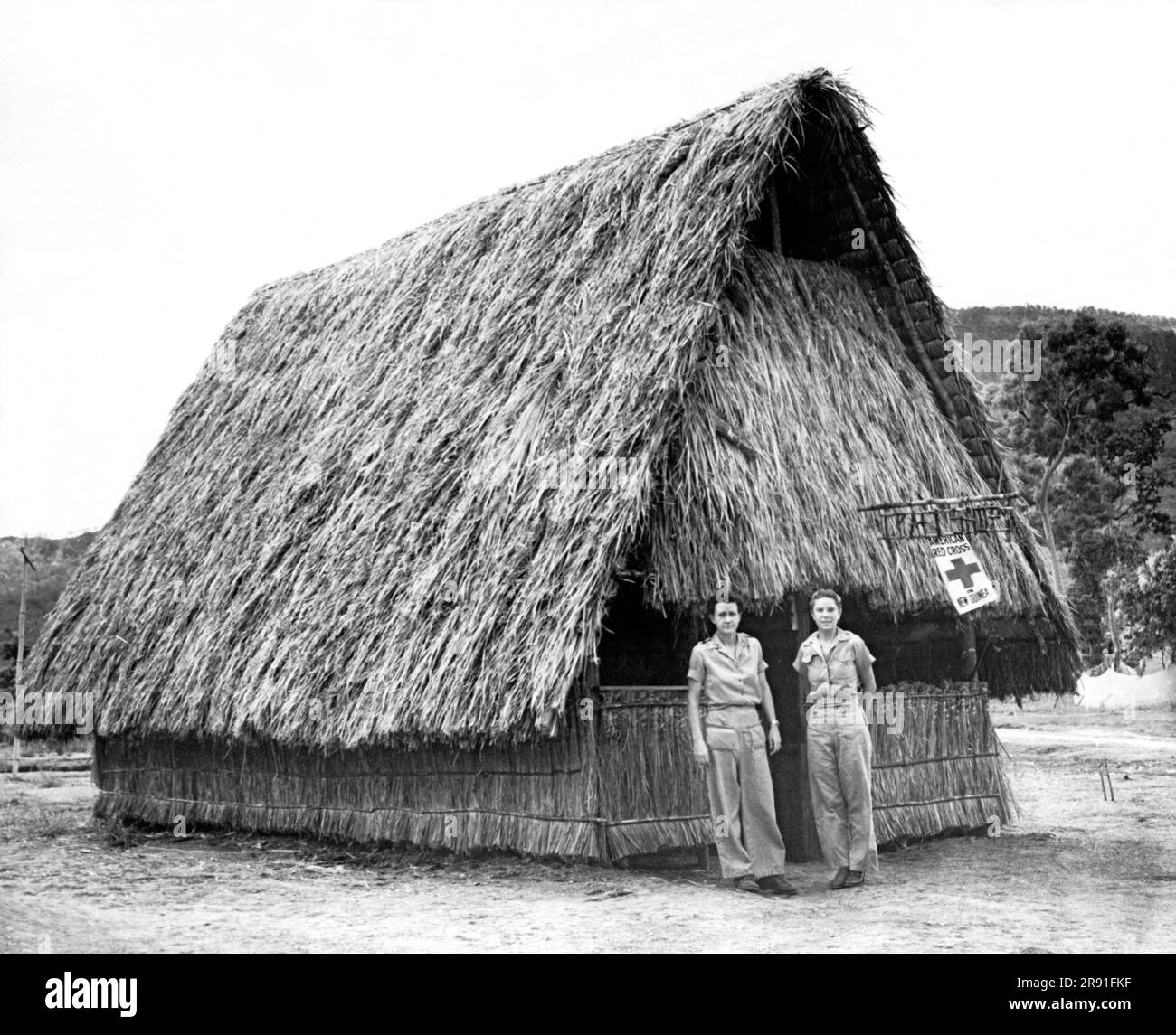 Nouvelle-Guinée : c. 1944 deux infirmières se tiennent devant leur refuge de la Croix-Rouge en Nouvelle-Guinée pendant la Seconde Guerre mondiale Banque D'Images