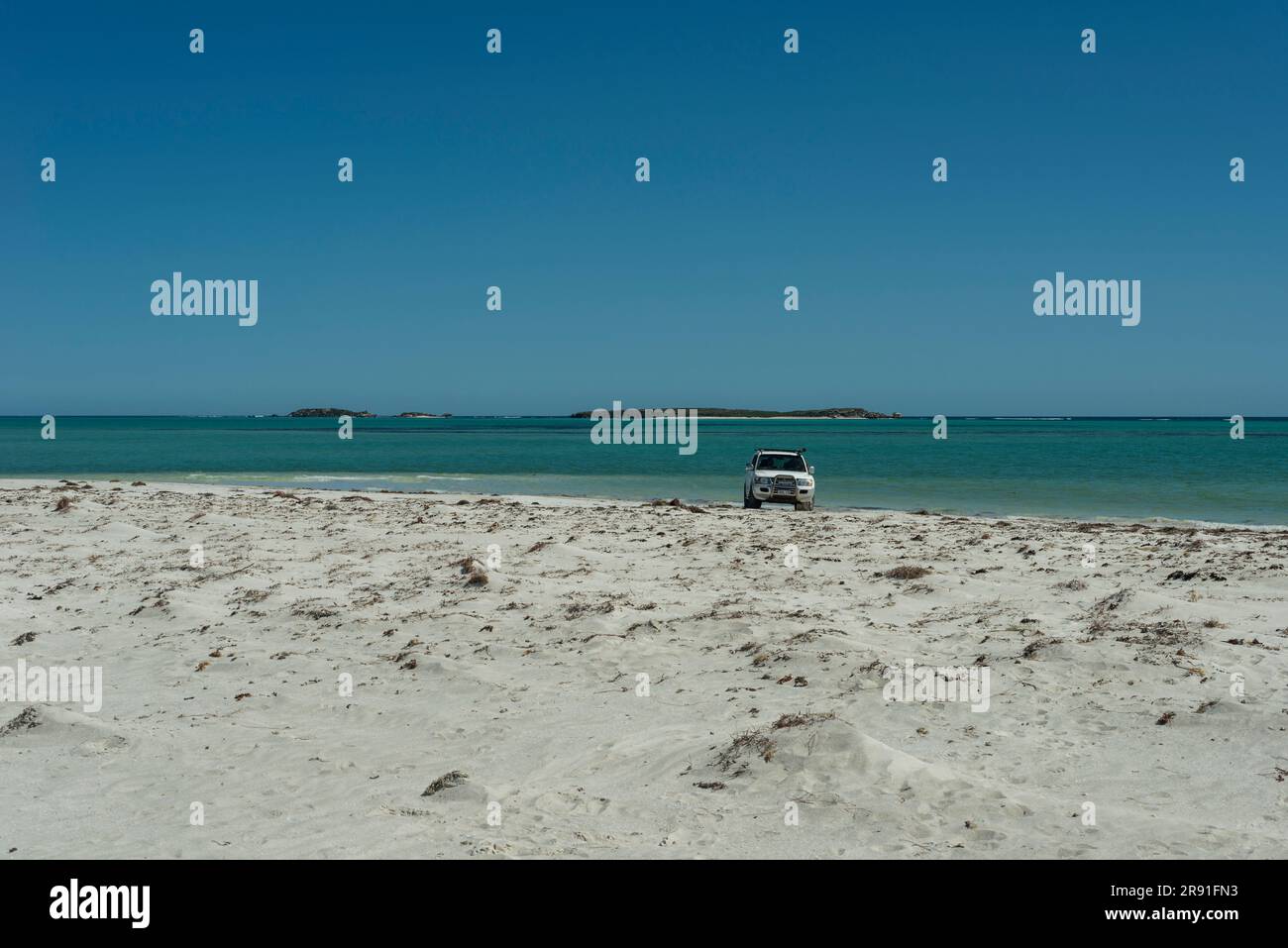 Un véhicule 4WD est stationné sur la plage avec la mer en arrière-plan en Australie occidentale Banque D'Images