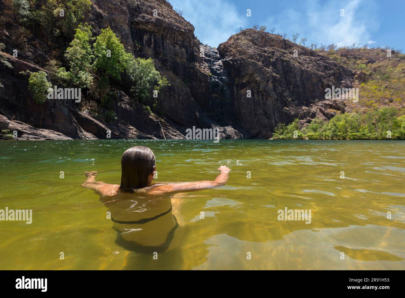 Une femme profite d'une baignade fraîche dans les eaux douces d'un trou de baignade dans le parc national de Kakadu en Australie Banque D'Images