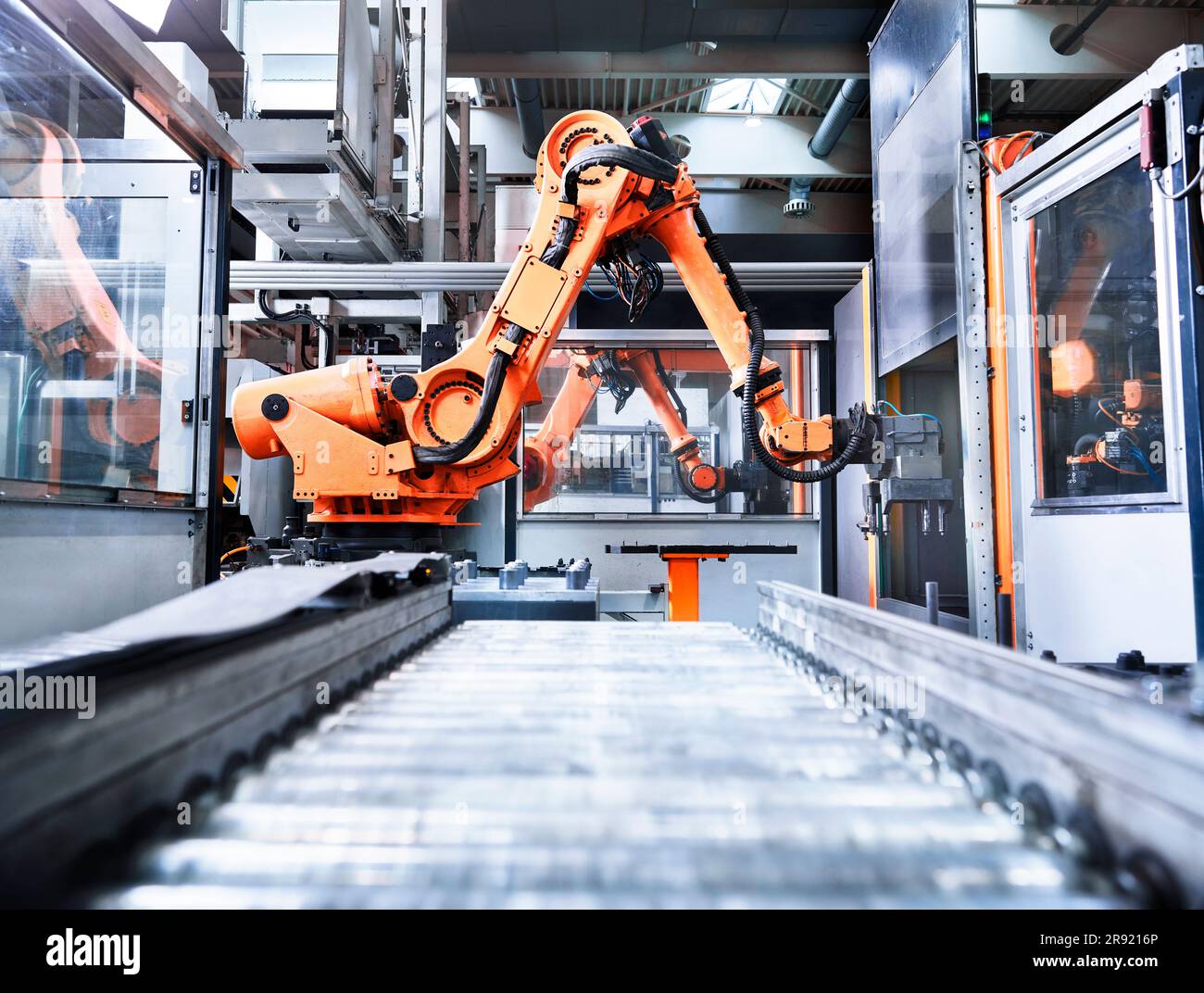 Bras robotisé sur tapis convoyeur en usine Banque D'Images