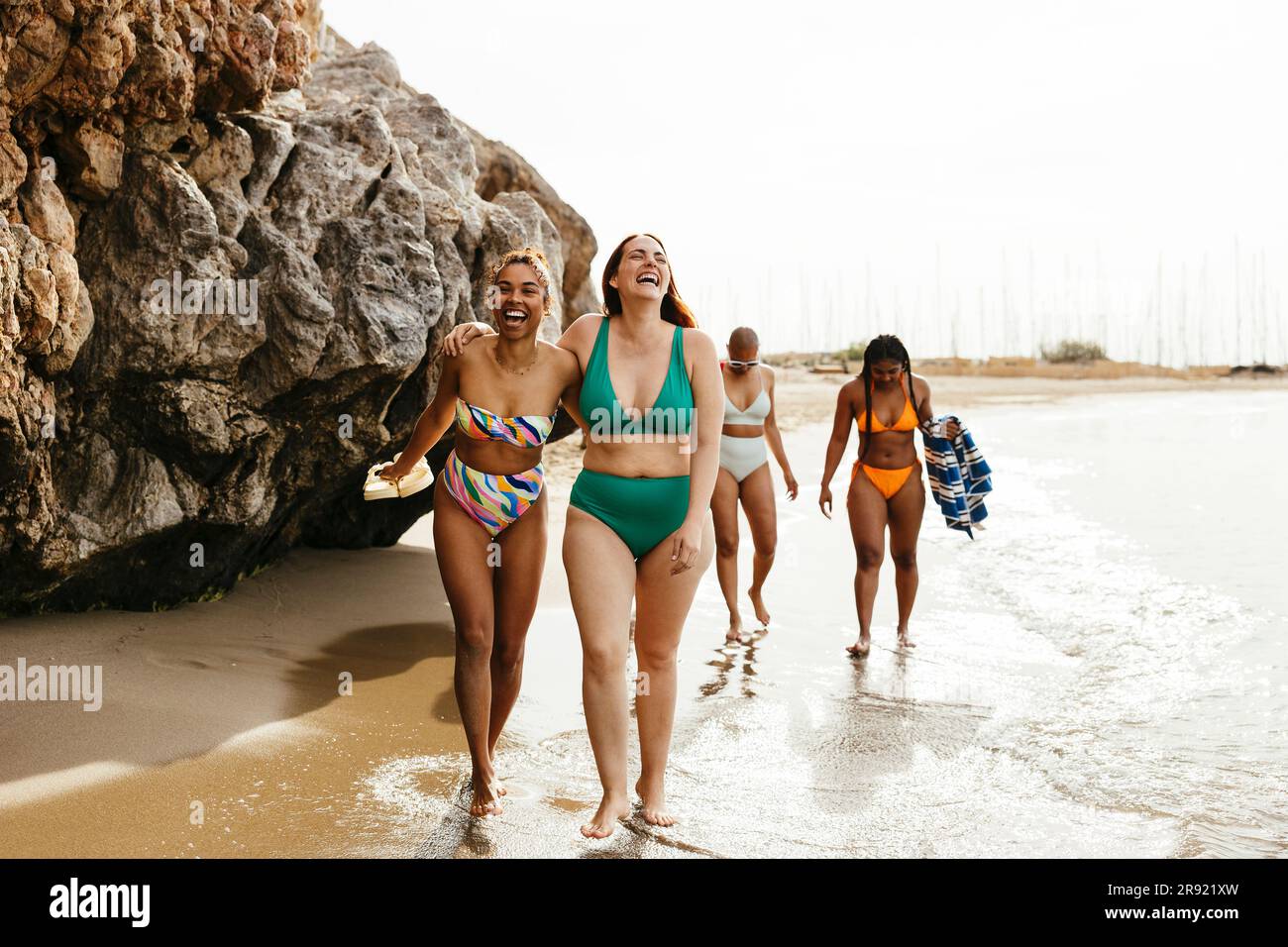 Des amis heureux marchant sur le rocher à la plage Banque D'Images