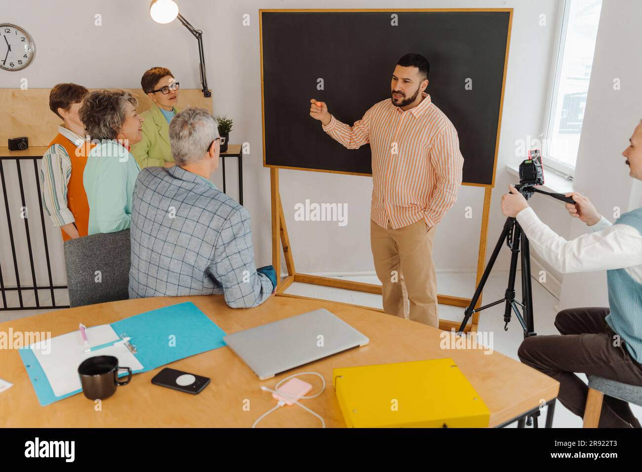 Homme debout devant un tableau noir tenant sur la classe de ligne Banque D'Images