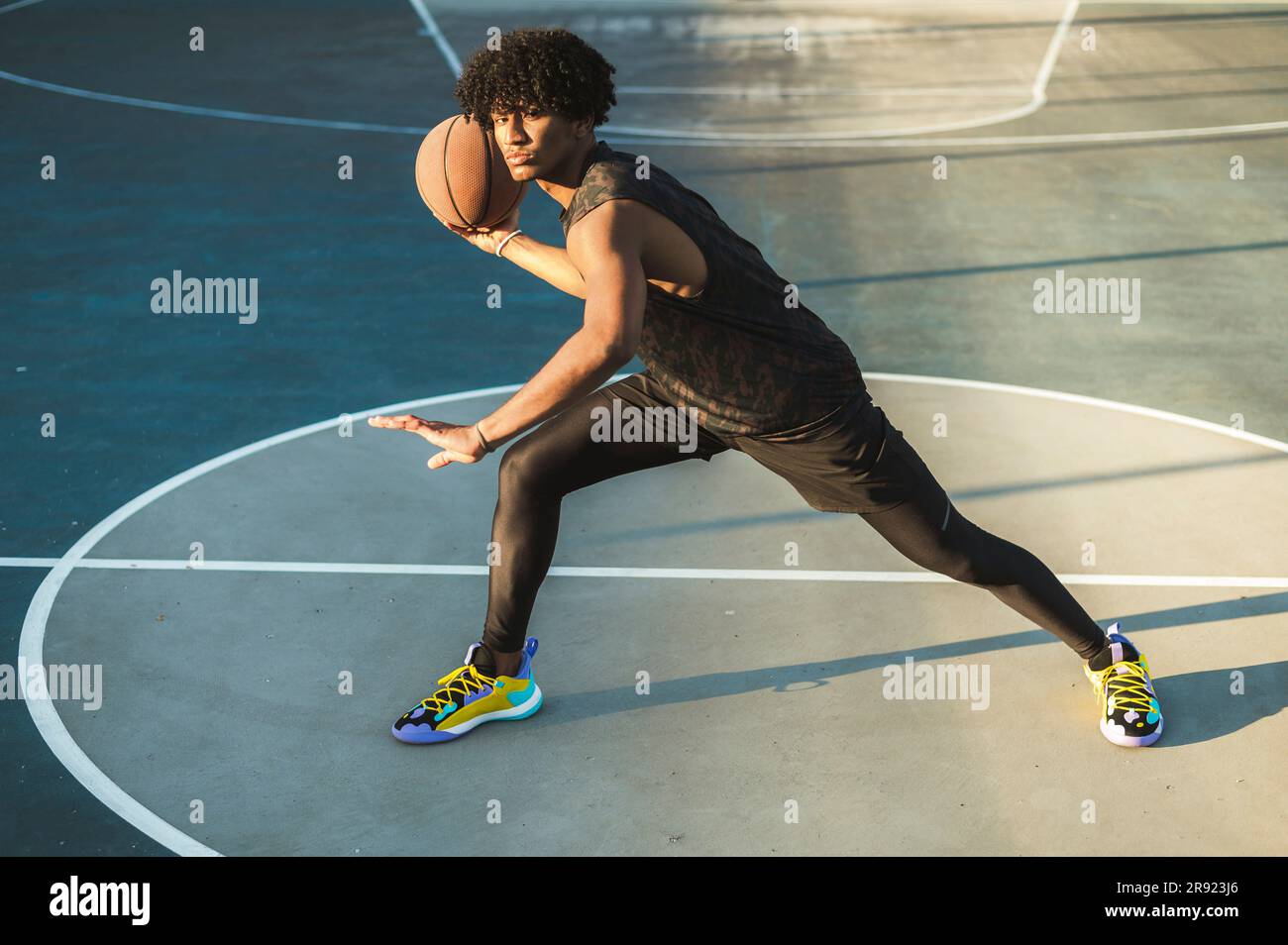 Athlète qui lance le basket-ball debout sur un terrain de sport Banque D'Images