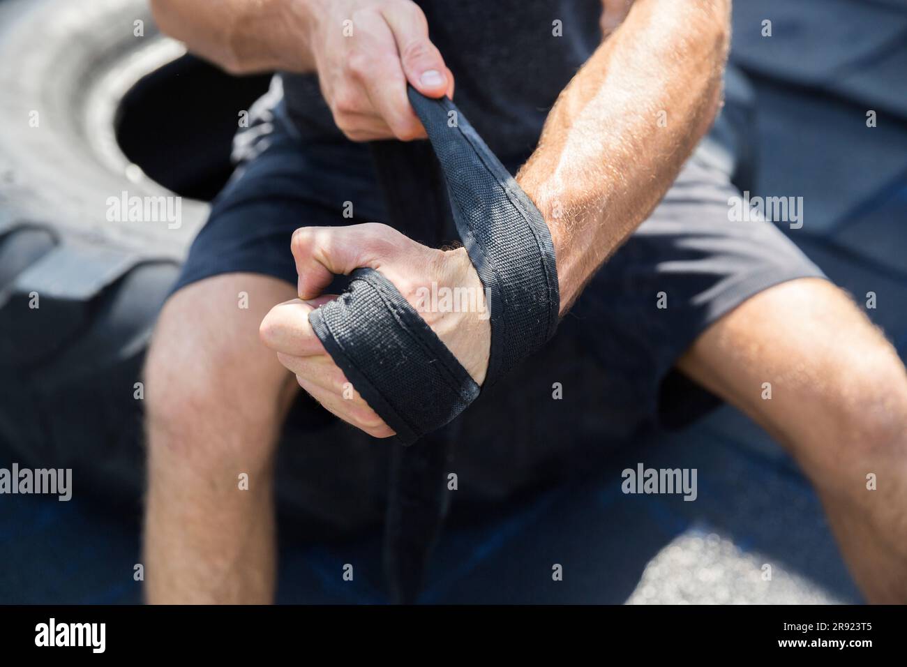 Homme enroulant la sangle à portée de main à la salle de gym située sur le toit Banque D'Images
