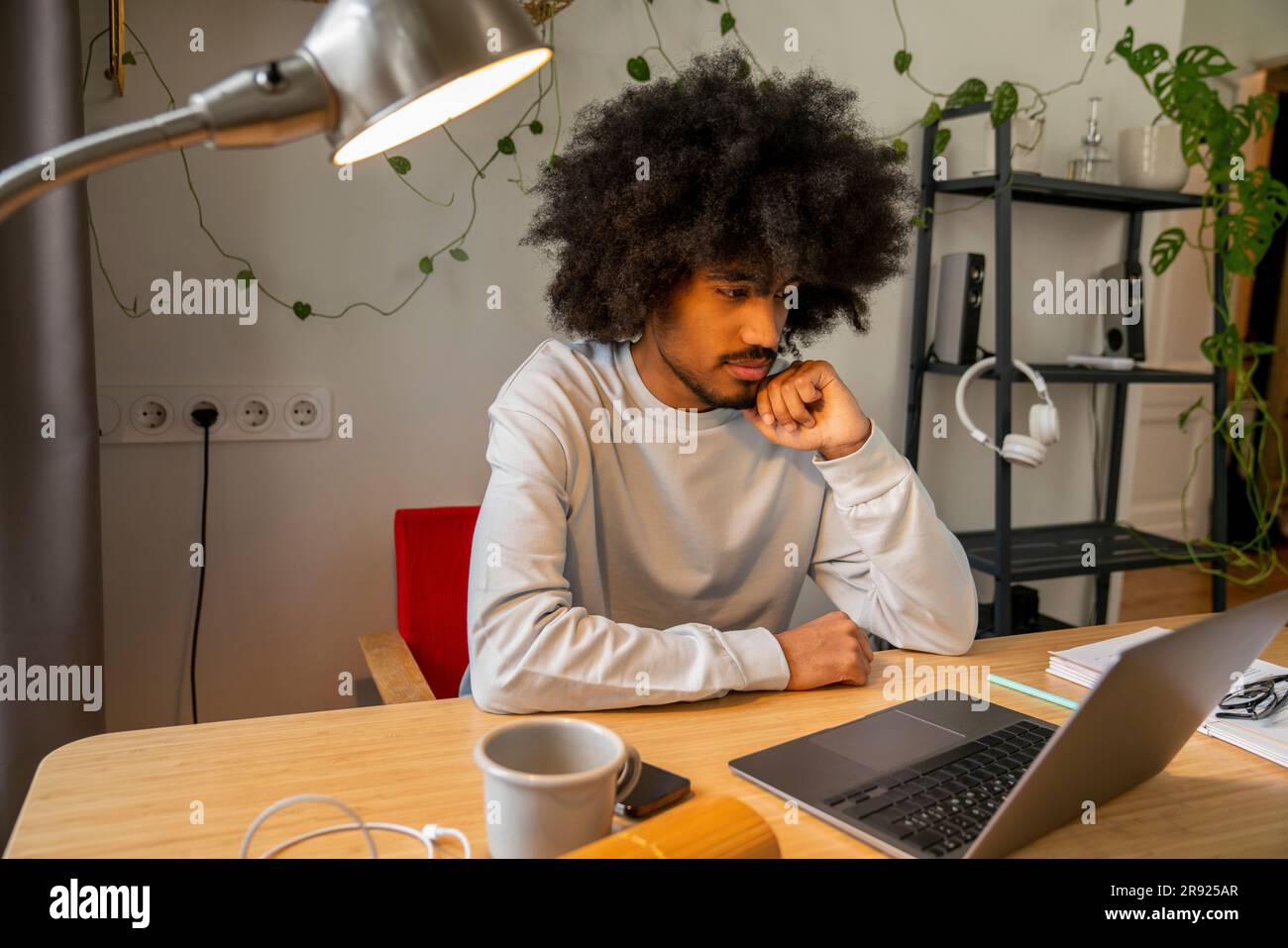 Travailleur indépendant concentré avec ordinateur portable sur le bureau à la maison Banque D'Images