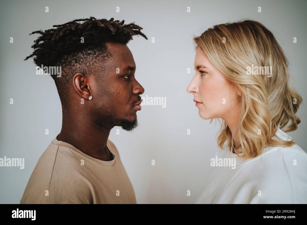 Couple regardant l'un l'autre sur fond gris Banque D'Images