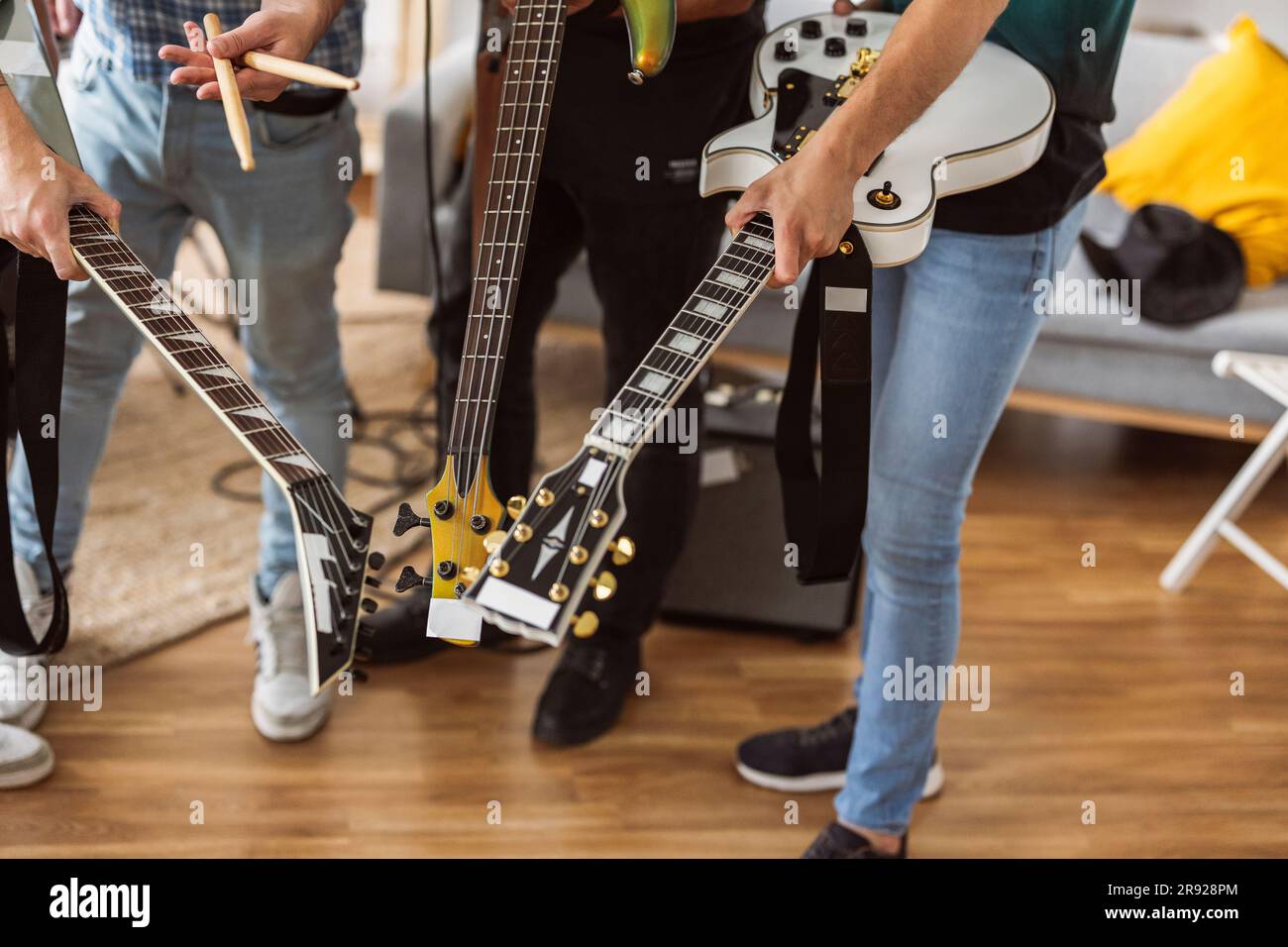 Musiciens debout avec des guitares et des pilons à la maison Banque D'Images