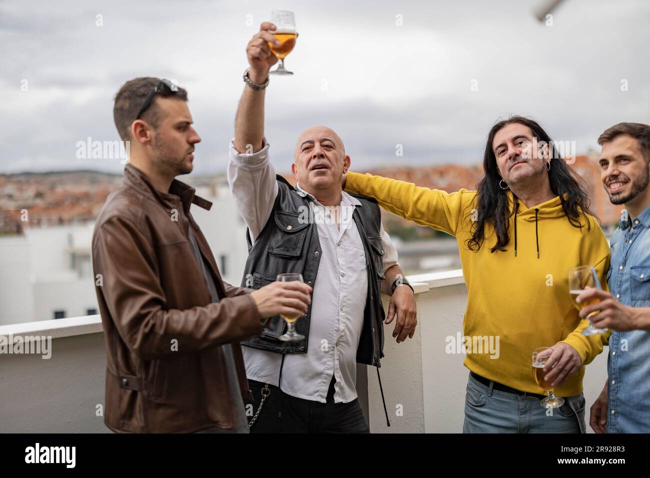 Des amis heureux dégustés en bière sur le toit Banque D'Images