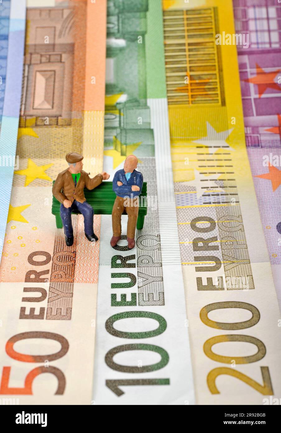 chiffres sur les billets en euros, deux retraités assis sur un banc de parc Banque D'Images