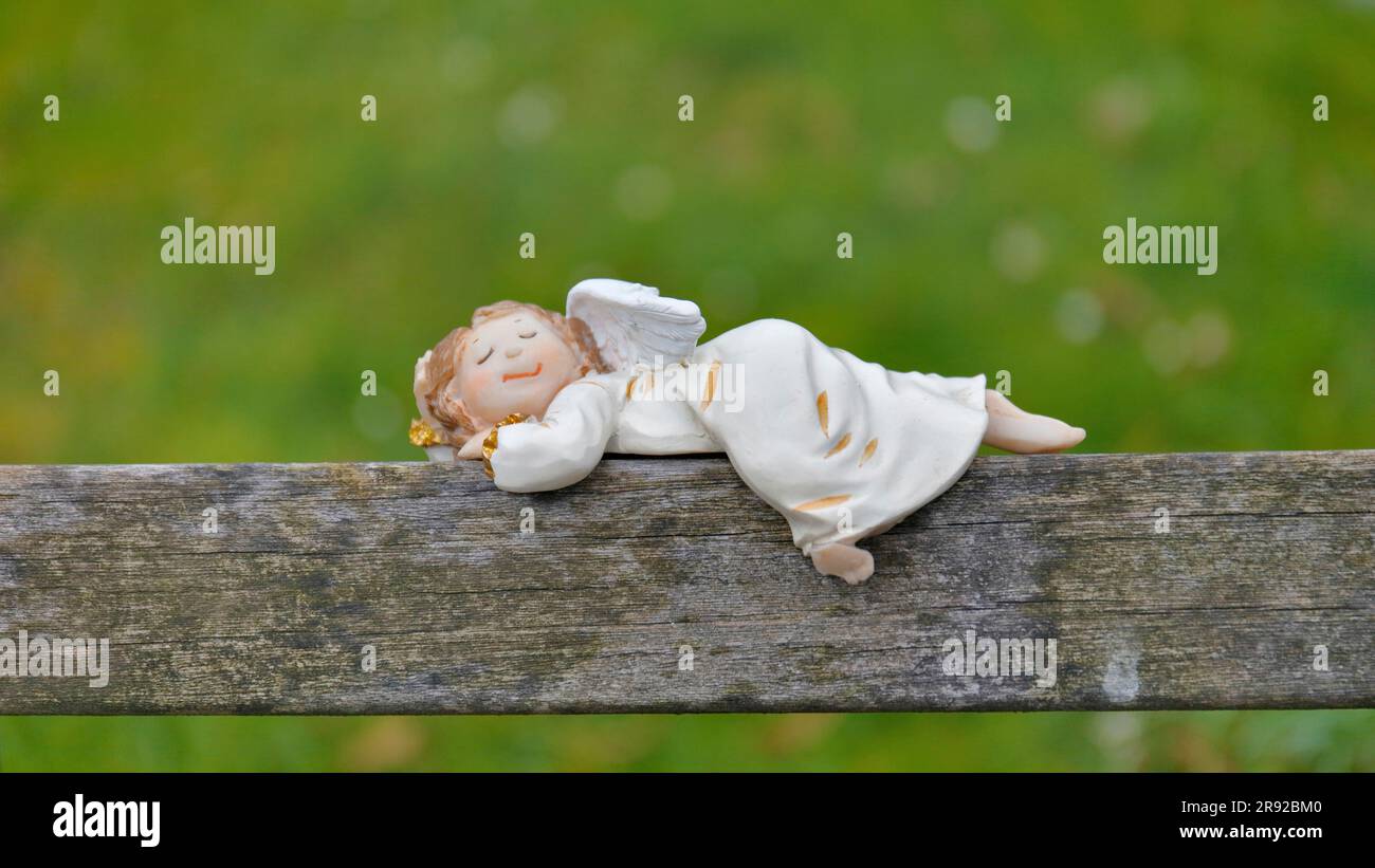 Jolie figurine ange repose sur une poutre en bois et dormir, Allemagne Banque D'Images