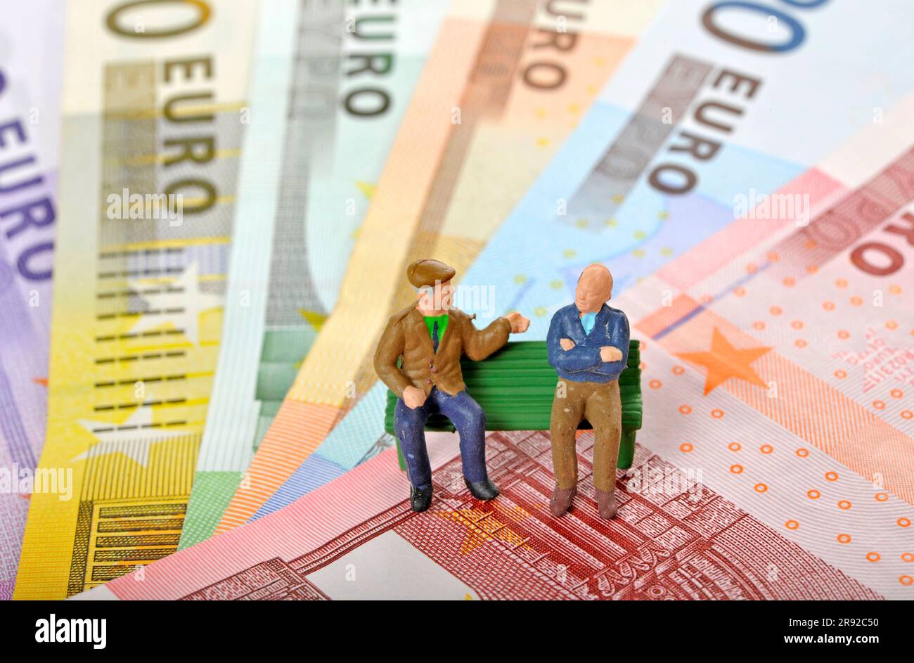 chiffres sur les billets en euros, deux retraités assis sur un banc de parc Banque D'Images