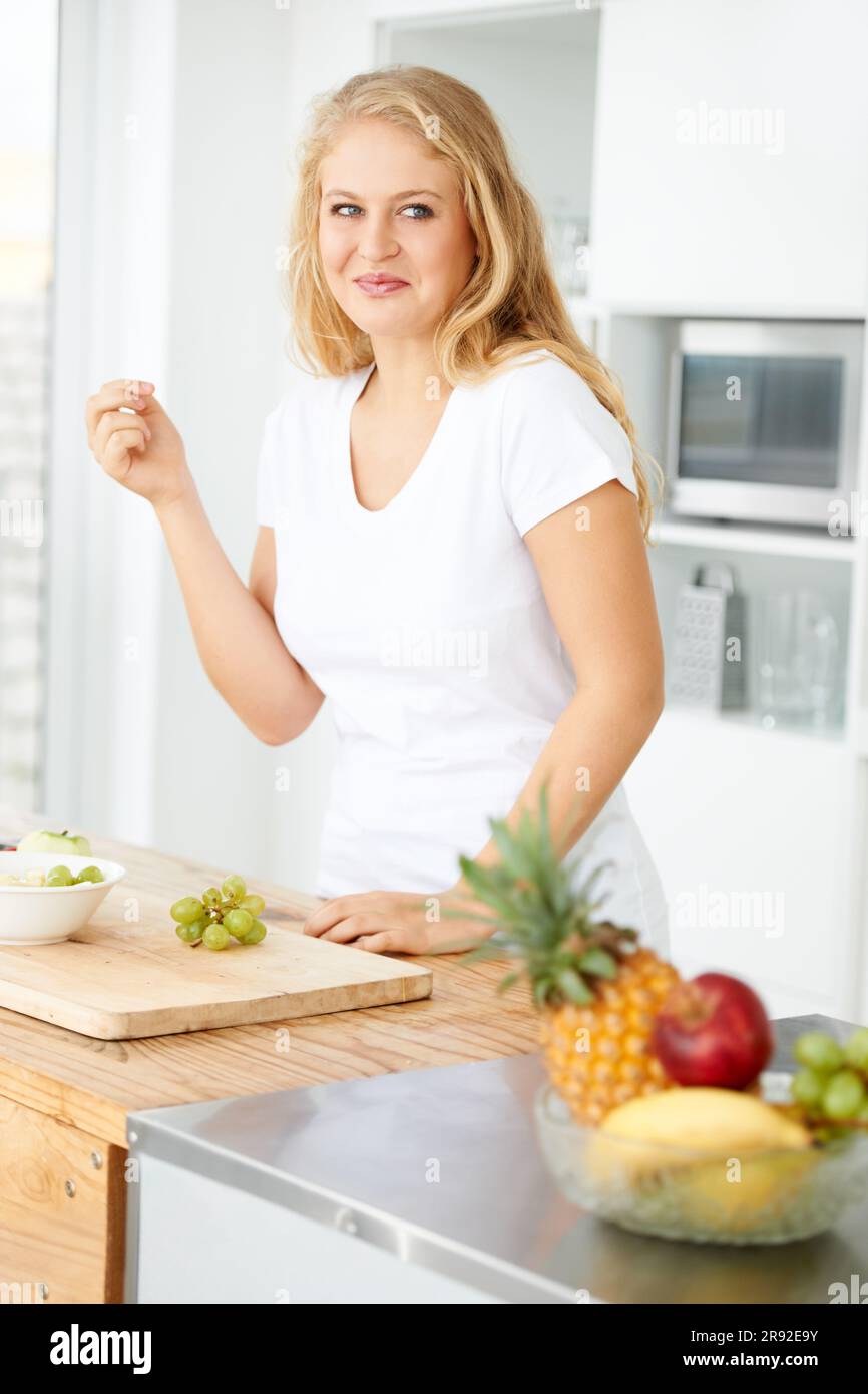 Fruits, en mangeant du raisin ou une femme pensant à un en-cas, un repas du matin ou un repas sain dans la cuisine maison. Idée de petit déjeuner, vegan ou fille heureuse avec des fruits Banque D'Images