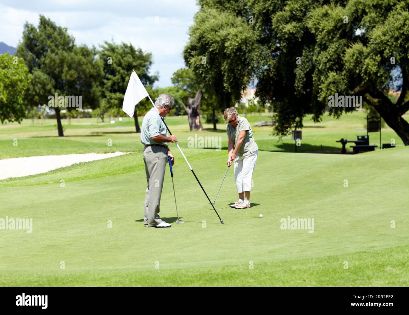 Homme avec drapeau, vieille femme ou golfeur sur le terrain de golf pour un birdie, en mettant un coup ou l'exercice à la retraite. Couple senior, joueur mature ou sérieux Banque D'Images