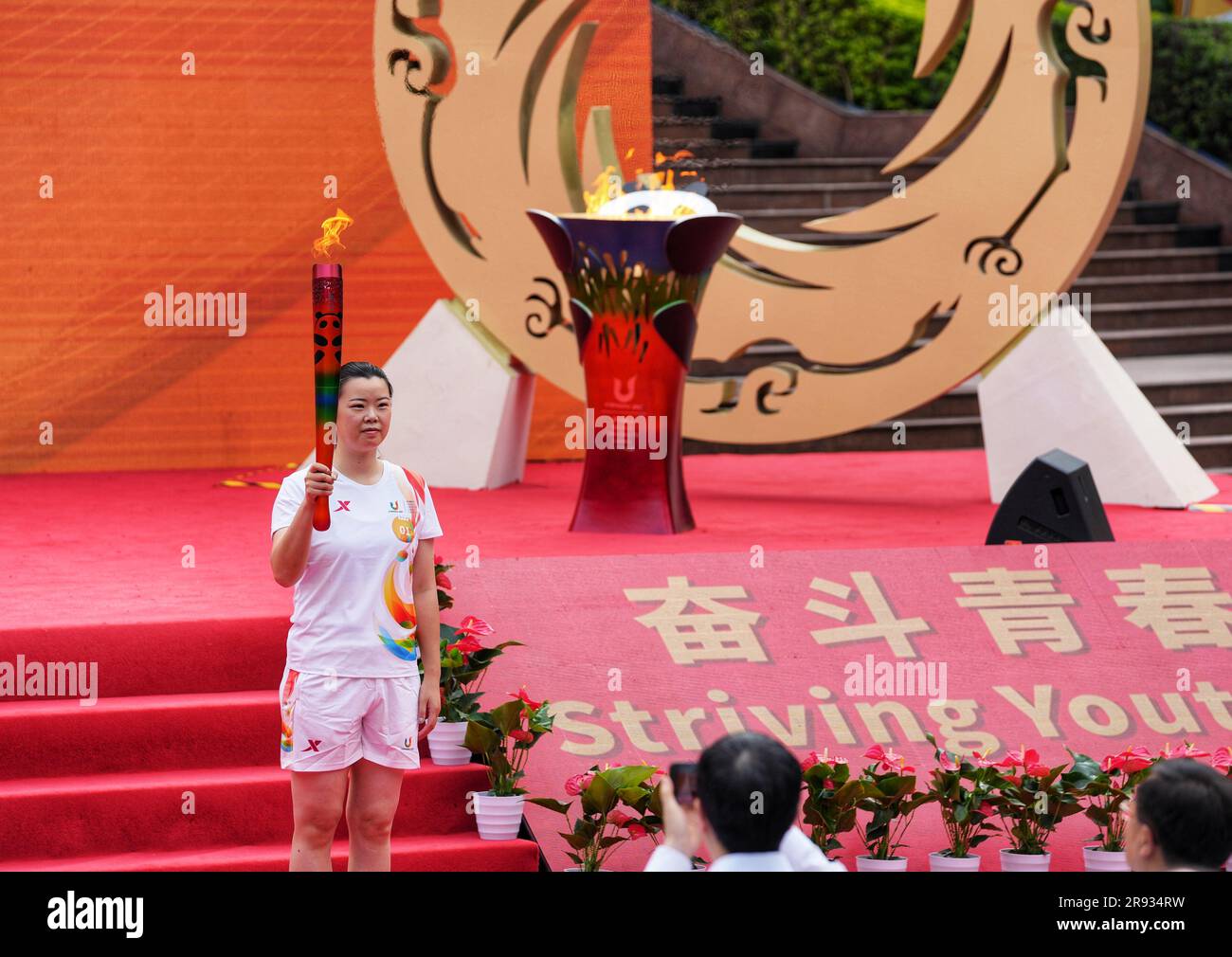 Chongqing. 24th juin 2023. Le porteur de la torche Li Xuerui tient la torche pendant le relais de la torche des Jeux de l'Université mondiale d'été de la FISU de Chengdu en 2021 à l'Université de Chongqing, dans la municipalité de Chongqing, au sud-ouest de la Chine, à 24 juin 2023. Credit: Liu Chan/Xinhua/Alay Live News Banque D'Images