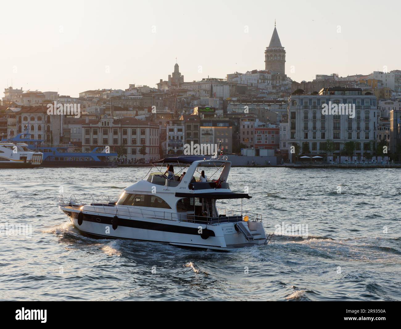 Vacanciers sur un bateau de luxe sur la Corne d'Or avec la Tour Galata derrière, Istanbul, Turquie Banque D'Images