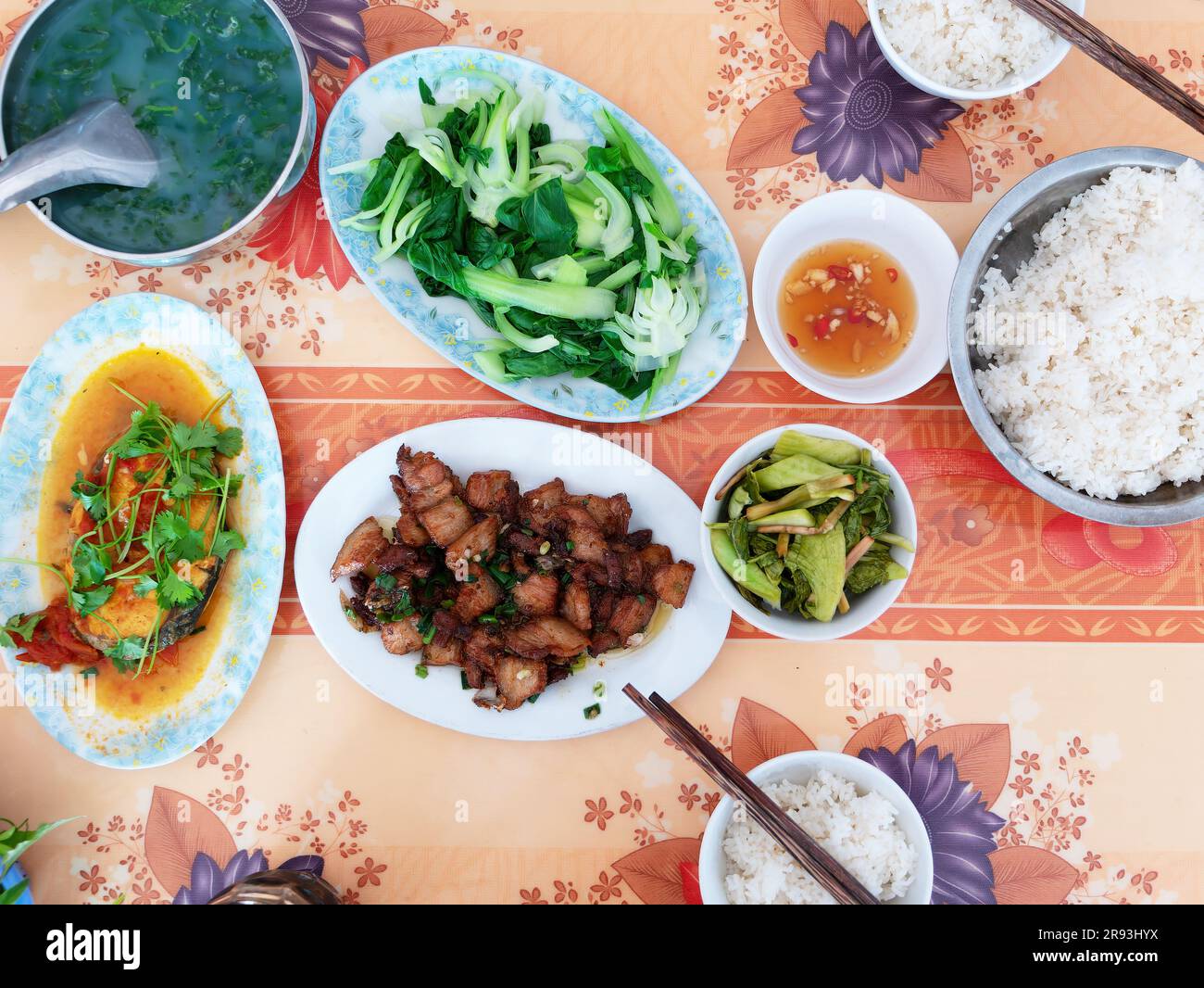 Table de déjeuner pour deux personnes dans un restaurant local à Thanh Hoa, Vietnam, avec riz, légumes, poisson, viande, condiments et soupe. Banque D'Images