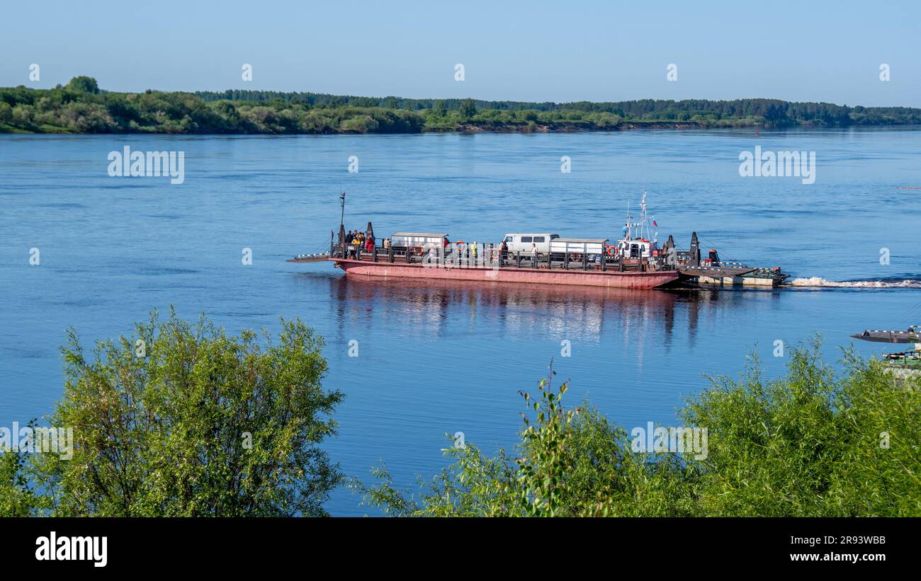 Vue lointaine d'un ferry en mouvement, un bateau à fond plat utilisé pour faire du ferry pour les personnes et les véhicules à la rive opposée lors du passage d'une rivière Banque D'Images