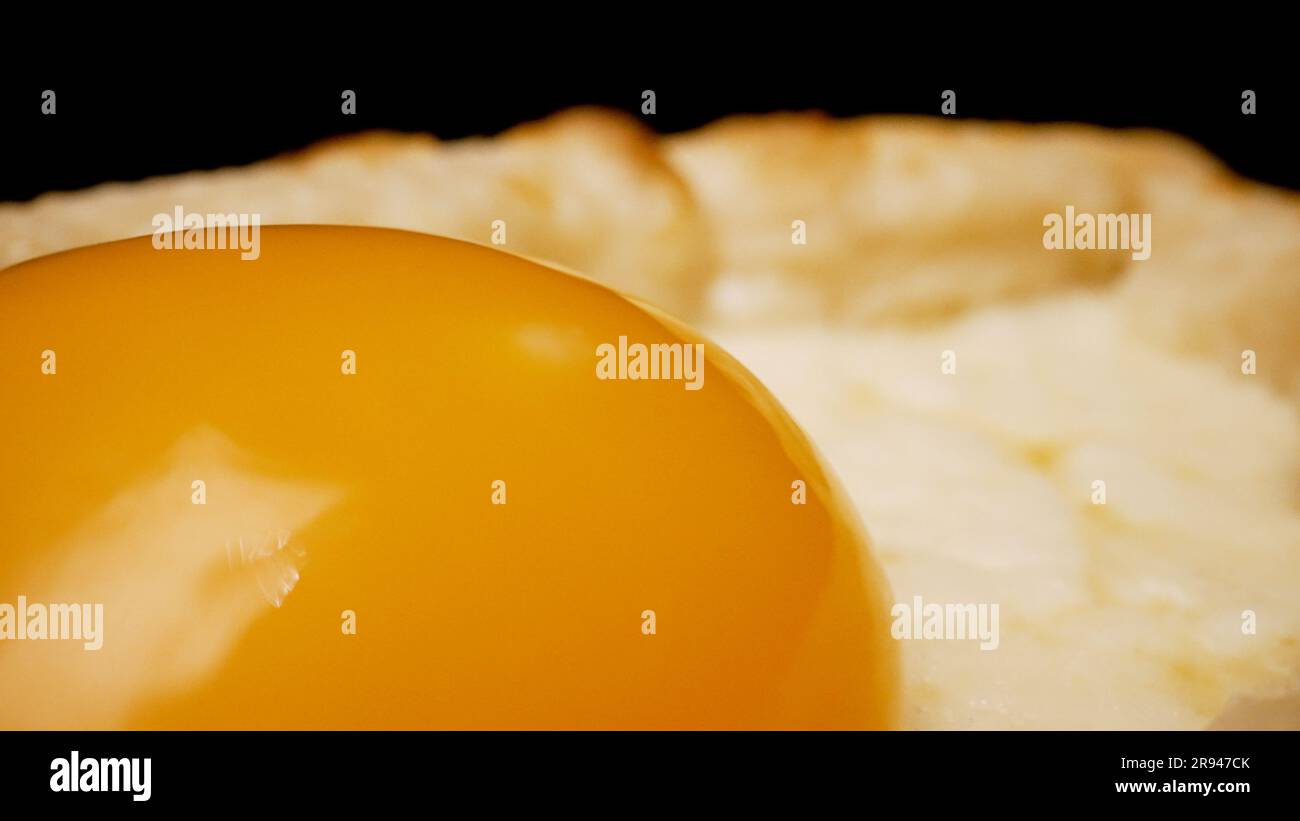 L'appareil photo tourne en cercle. Gros plan sur le khachapuri adjarien avec un œuf brut. Gros plan sur le khachapuri adjarien, gros plan sur le jaune d'œuf. Banque D'Images