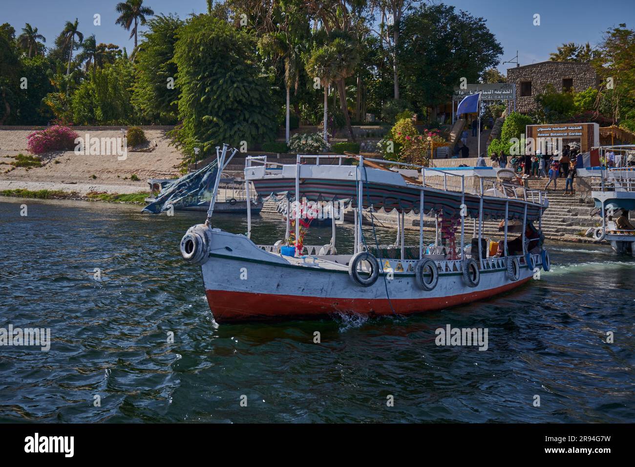 Fleuve du Nil à Assouan, Égypte photo de l'après-midi montrant des felouques et des bateaux dans le fleuve devant l'entrée du jardin botanique d'Assouan Banque D'Images