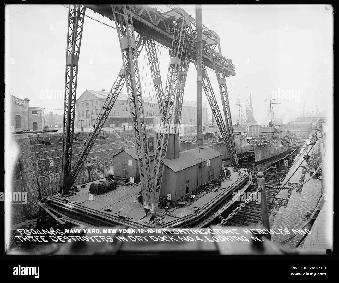 Grue flottante Hercules et trois destroyers dans le quai sec numéro 4 regardant vers le nord. Négatifs en plaques de verre de la construction et de la réparation de bâtiments, d'installations et de navires au New York Navy Yard. Banque D'Images