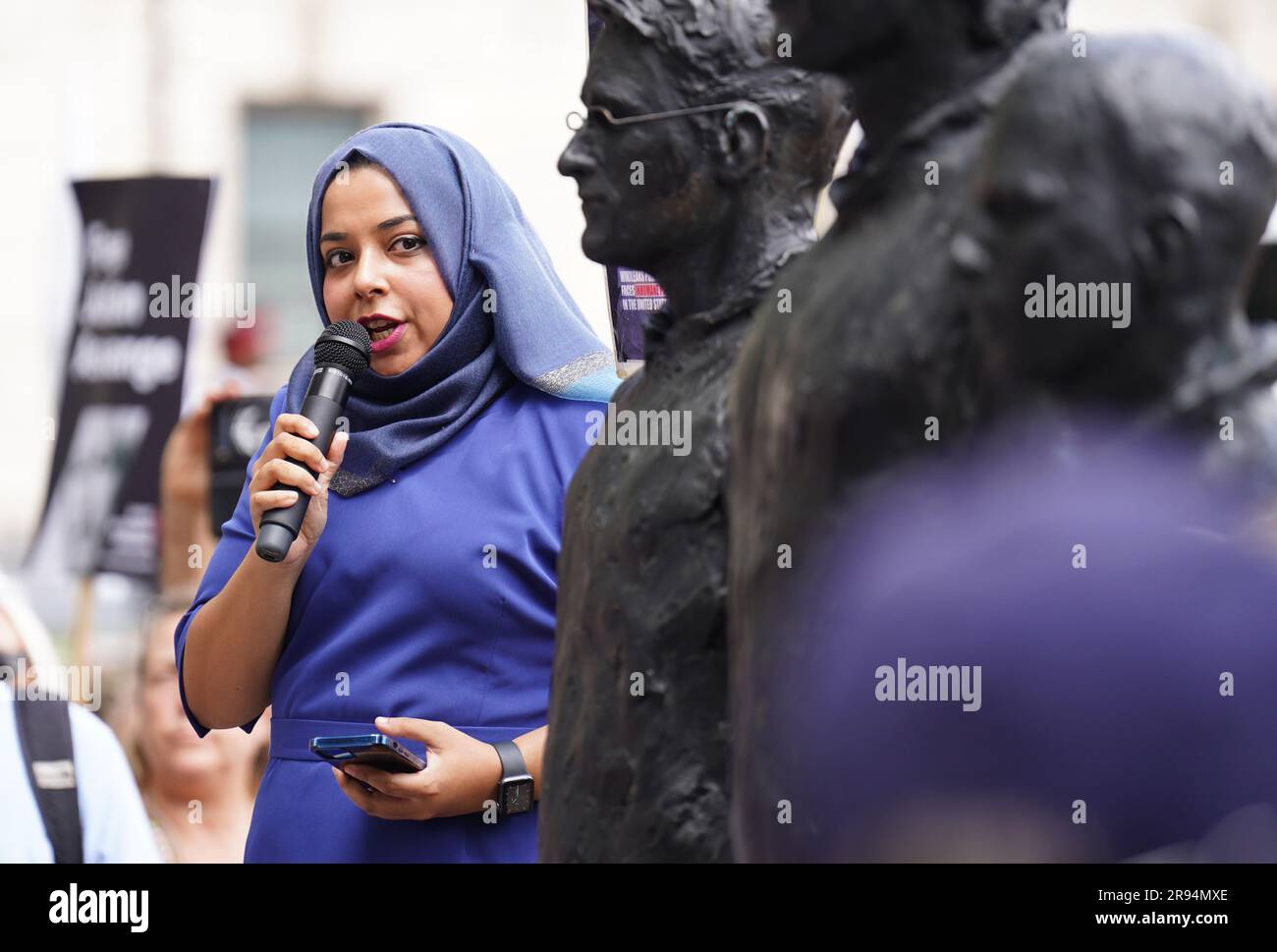 L'APsana Begum parle aux côtés d'une sculpture appelée tout ce qu'il faut dire, Qui présente des figures de bronze grandeur nature des dénonciateurs (gauche-droite) Edward Snowden, Julian Assange et Chelsea Manning, chacun debout sur leur propre chaise, sur la place du Parlement, à Londres, lors d'une protestation visant à intensifier les demandes de libération du fondateur de WikiLeaks, Julian Assange. Les militants et les partisans défileront dans le centre de Londres alors qu'Assange sera extradé vers les États-Unis, où il craint d'être emprisonné pour le reste de sa vie. Date de la photo: Samedi 24 juin 2023. Banque D'Images