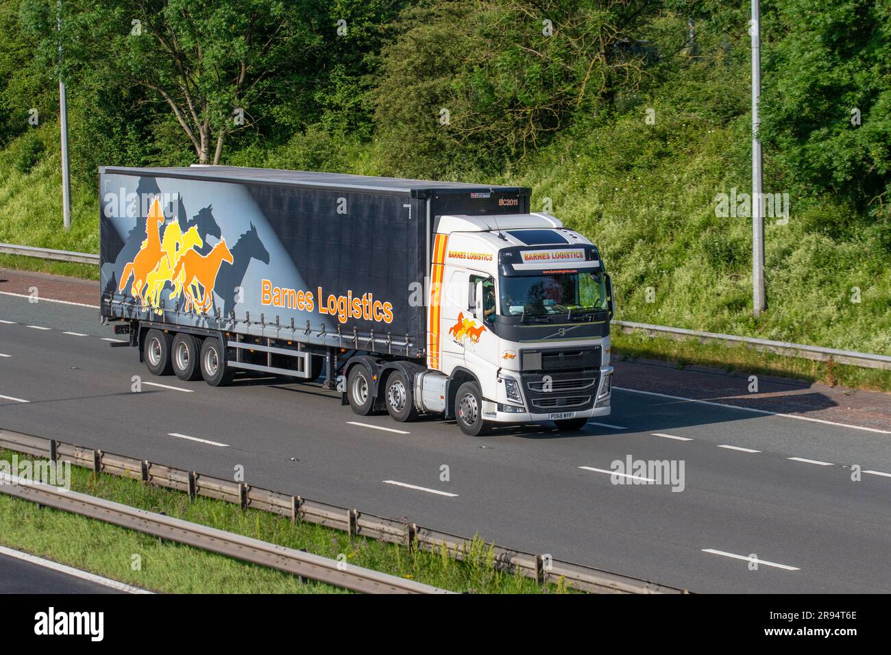 LE GROUPE BARNES Logistics sécurise l'entreposage et le stockage. 2018 Volvo FH, camion à flancs de rideaux circulant sur l'autoroute M6 du Grand Manchester, Royaume-Uni Banque D'Images