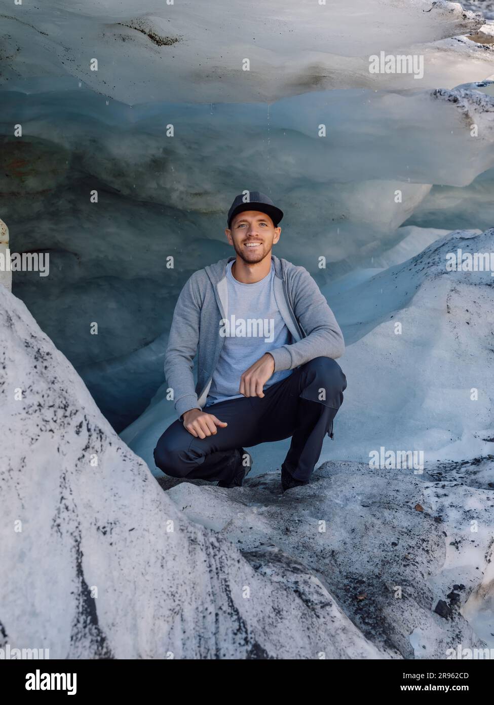 Randonneur souriant sous un grand glacier. Glacier et touriste Banque D'Images
