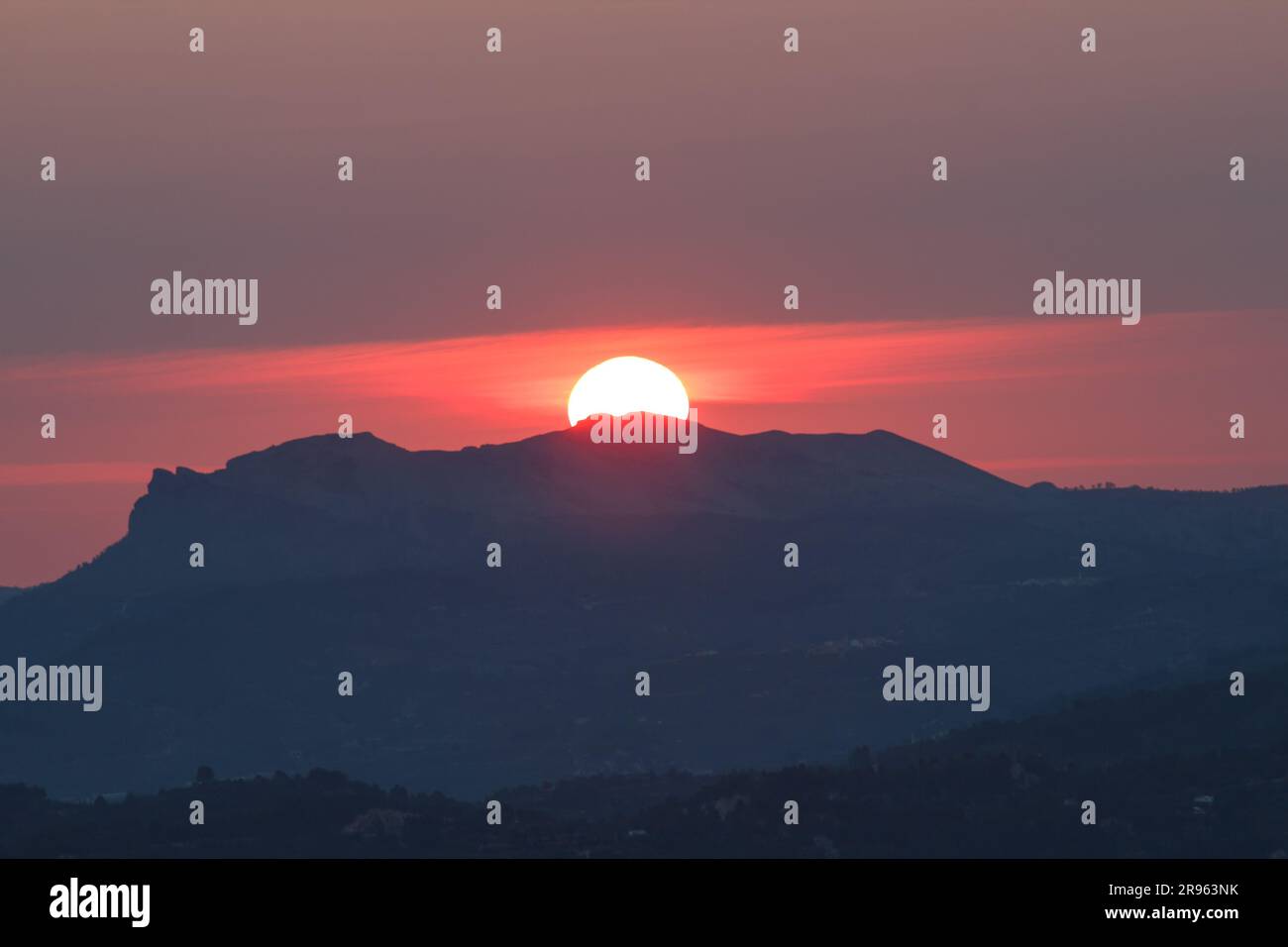 Aube le plus long jour de l'année, solstice d'été, au-dessus de la Sierra de la Safor de la Cruz de Alcoy, Espagne Banque D'Images