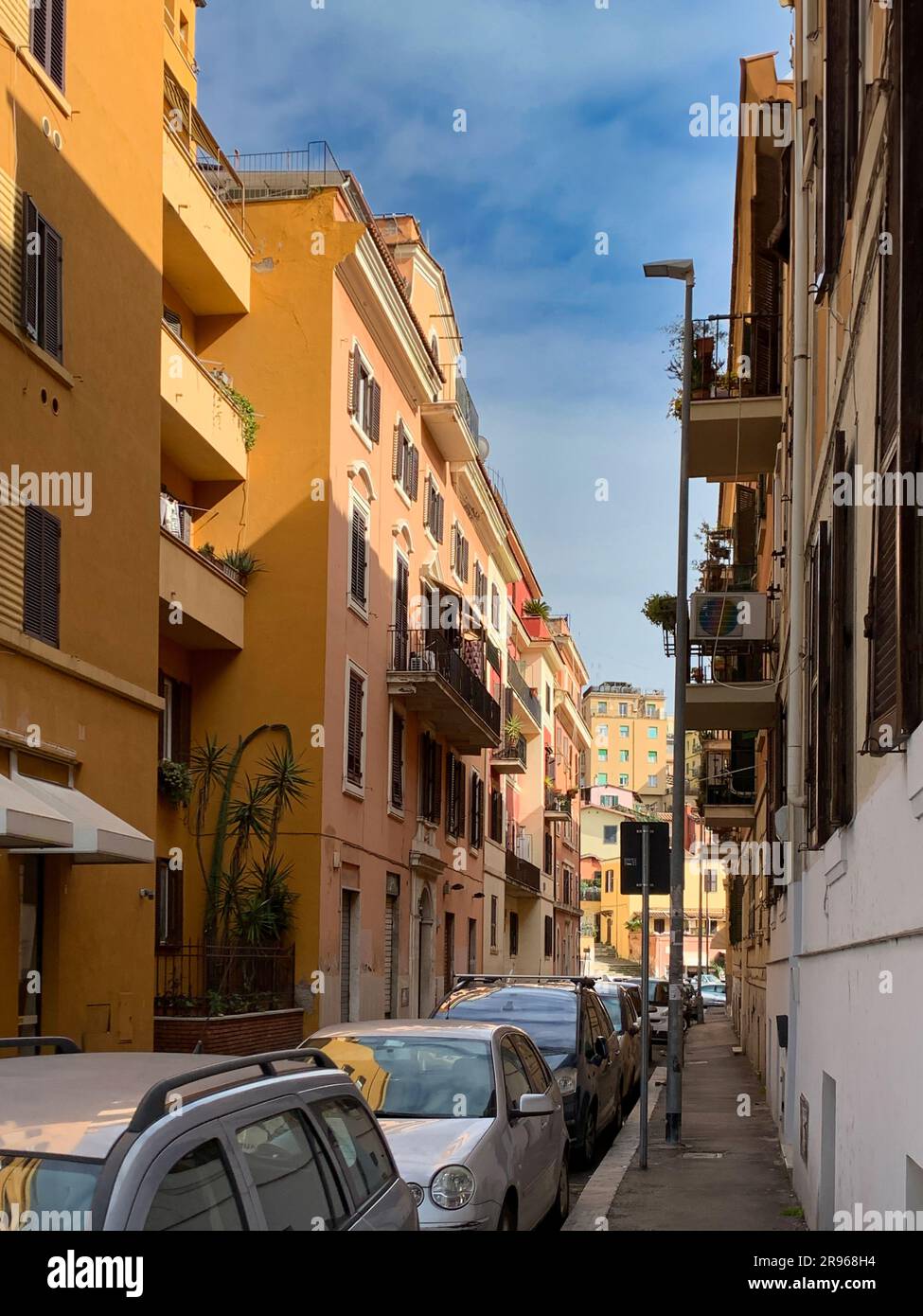 Un cliché vertical de la via dell'Argilla, une rue centrale de Rome, bordée de voitures garées et de bâtiments des deux côtés. La rue est dépourvue de personnes Banque D'Images