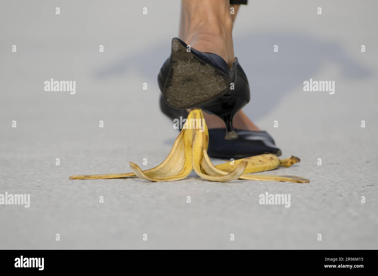 Femme avec des chaussures à talons hauts marchant sur Banana Peel Banque D'Images