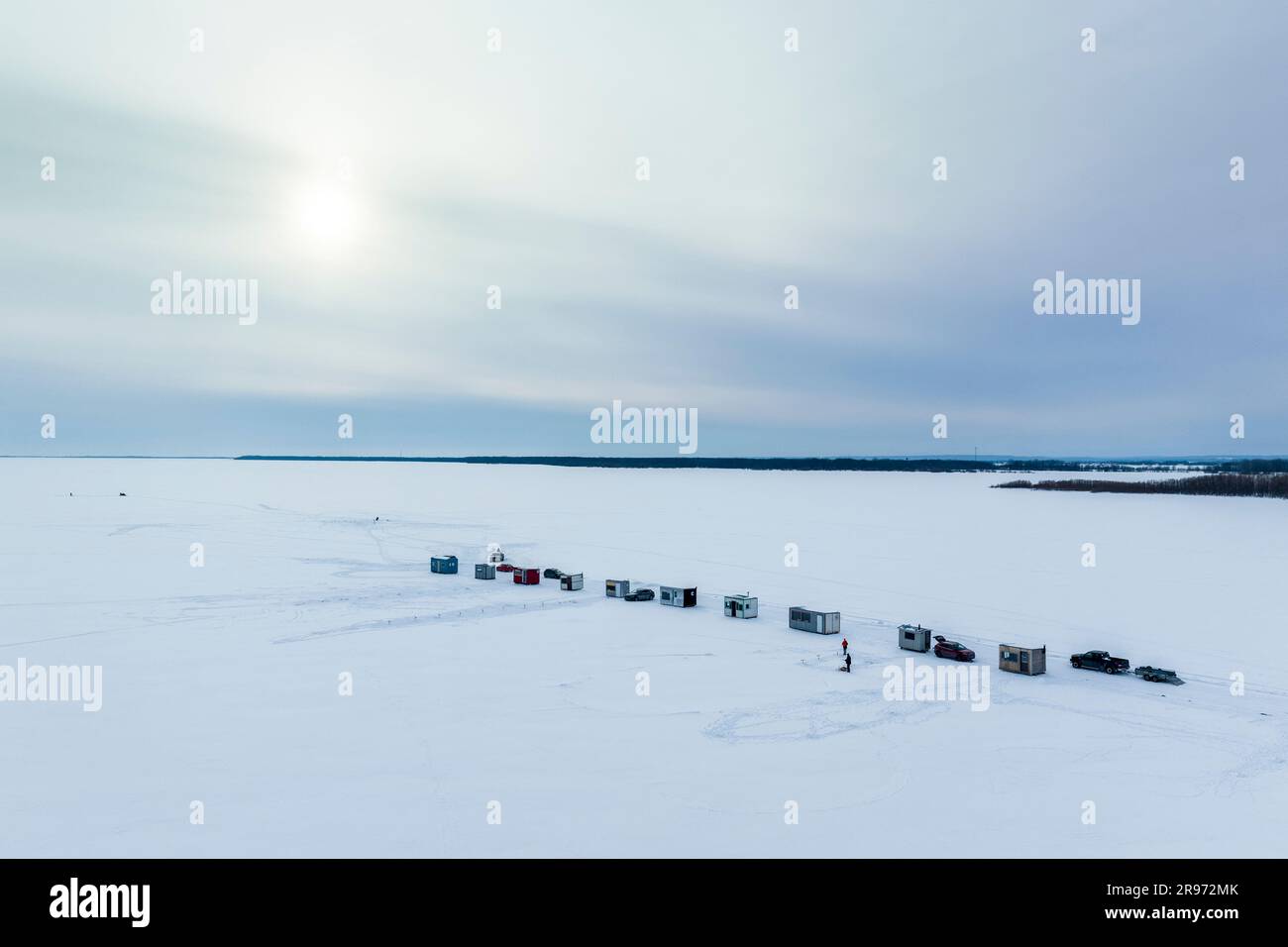 Vue aérienne des cabanes de pêche sous la glace le long des rives de la rue Fleuve Lawrence en hiver au Canada. Banque D'Images