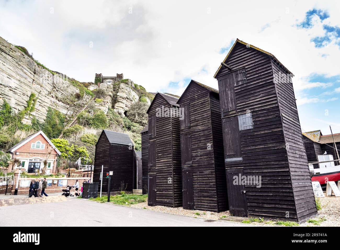 Boutiques de filets tarrés historiques pour le stockage de filets de pêche au Stade, Hastings Castle en arrière-plan, Hastings, Angleterre Banque D'Images