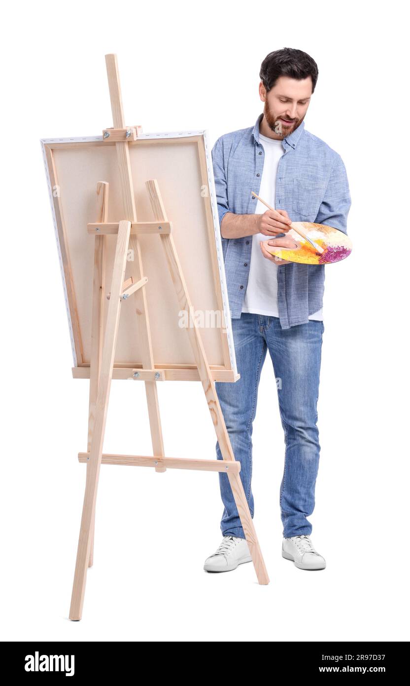 Homme peignant avec un pinceau sur fond blanc. Utilisation du chevalet pour tenir la toile Banque D'Images