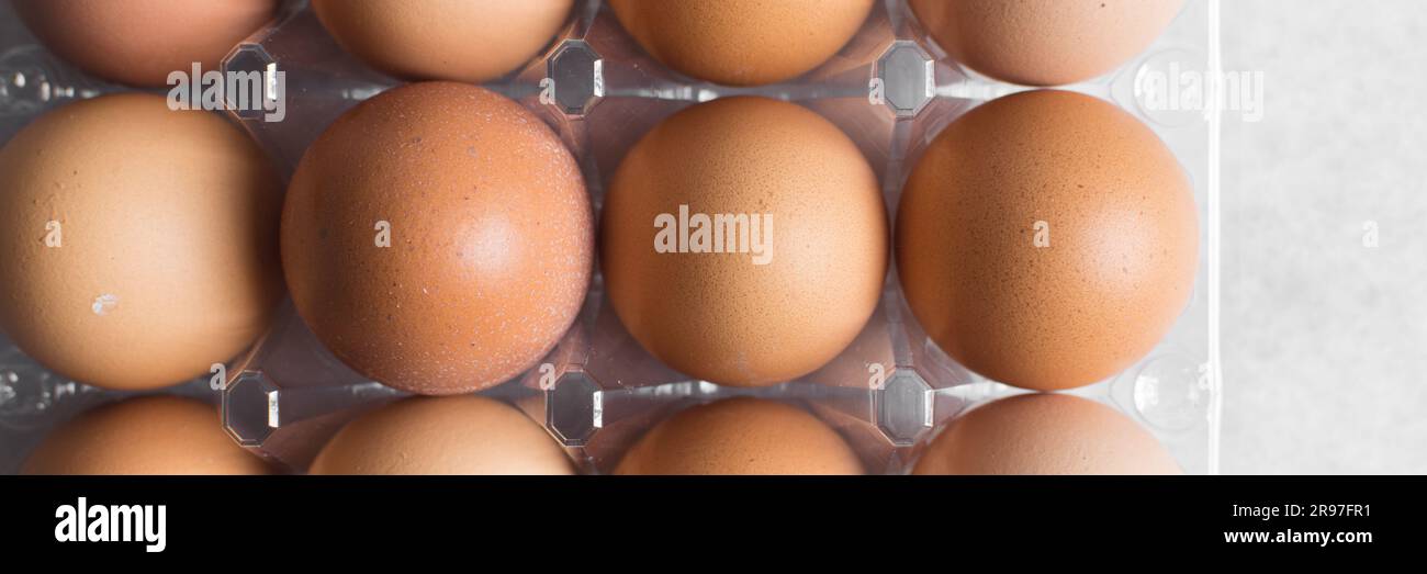 Vue de dessus d'une caisse d'œufs sur une surface en marbre, d'œufs dans une caisse en plastique transparent, d'œufs biologiques sur une table Banque D'Images