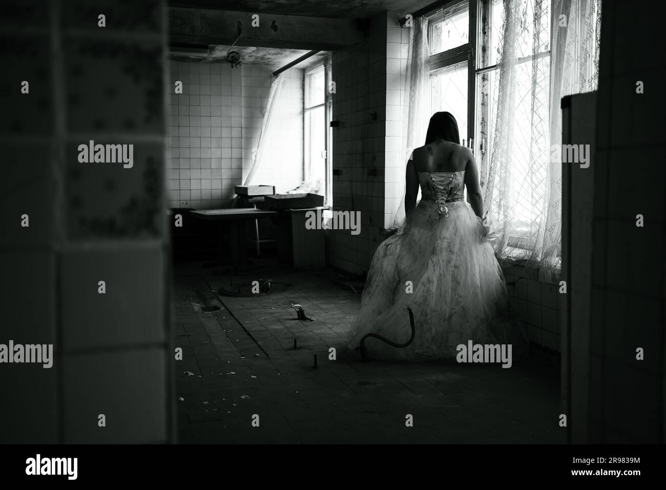 Nuit d'horreur, fantôme de mariée dans la maison hantée, mystérieuse femme en robe blanche debout dans le bâtiment abandonné Banque D'Images