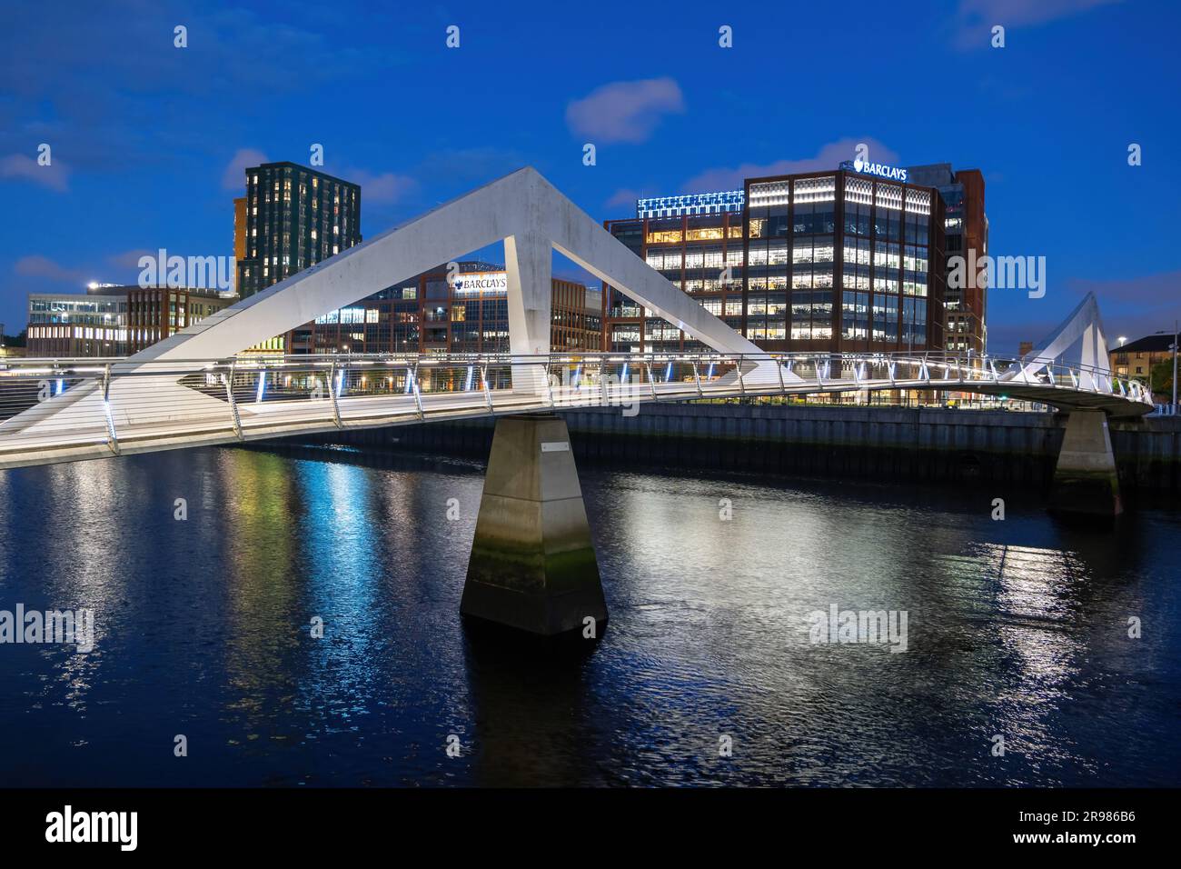 Squigggly Bridge ou Tradeston Bridge sur la rivière Clyde la nuit à Glasgow, vue sur la ville avec Barclays Clyde place, Écosse, Royaume-Uni. Banque D'Images