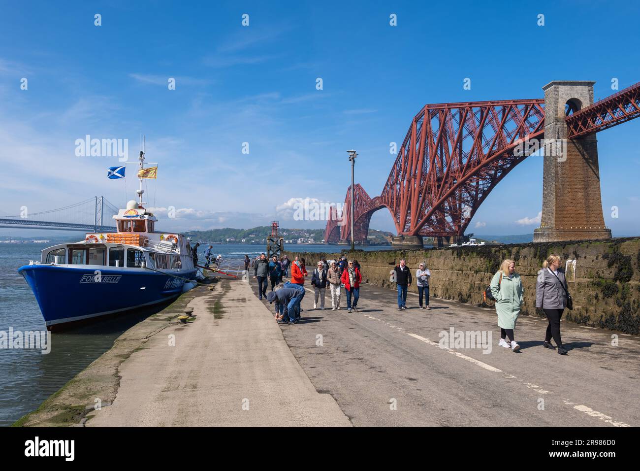 Les personnes quittant le bateau de visite au Forth Bridge, après un voyage autour des trois ponts à Queensferry, en Écosse, au Royaume-Uni, le célèbre pont ferroviaire en porte-à-faux de Banque D'Images