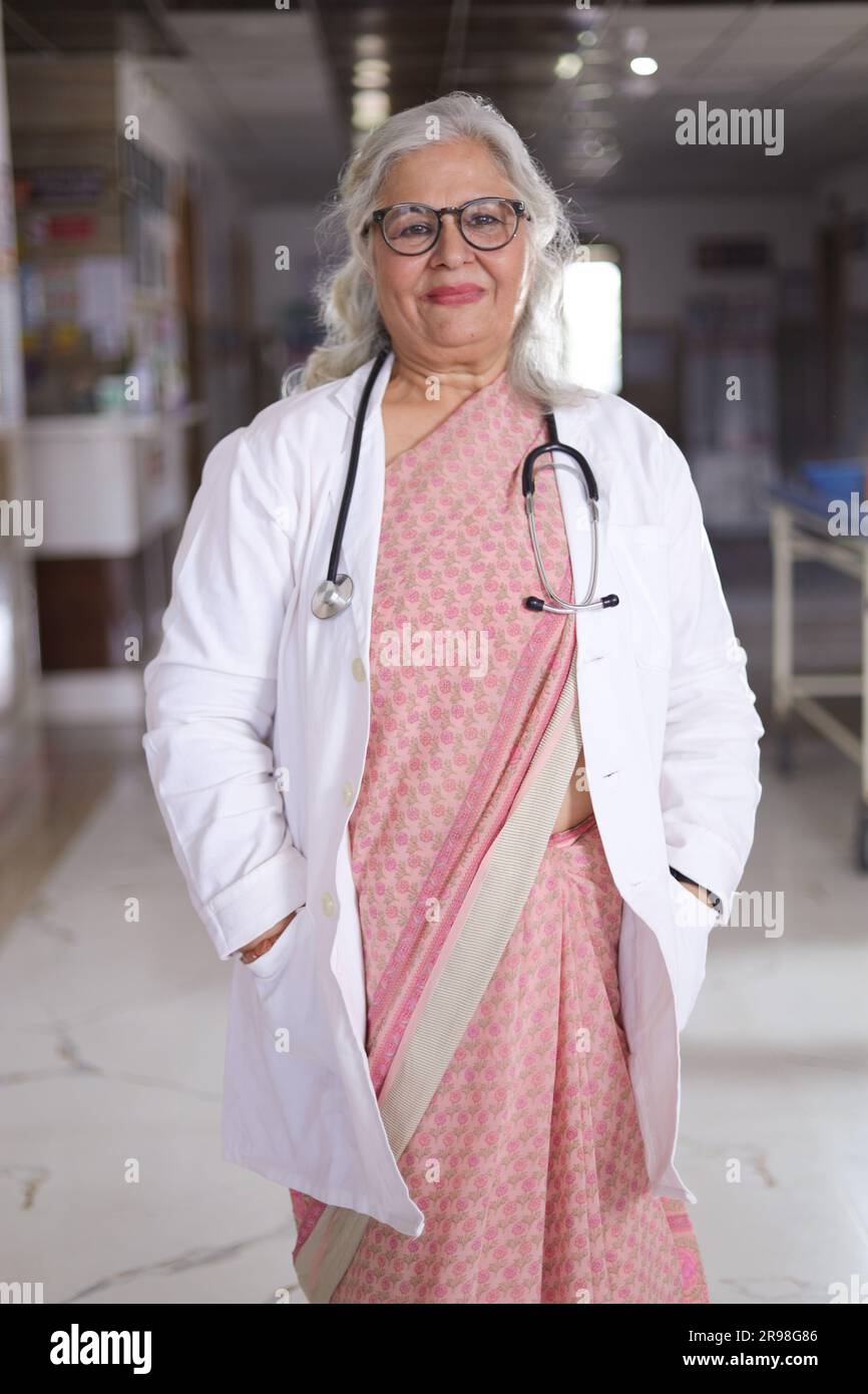 Portrait de femme médecin senior avec les bras croisés debout dans le couloir de l'hôpital. Heureux docteur indien blouse blanche de laboratoire Banque D'Images