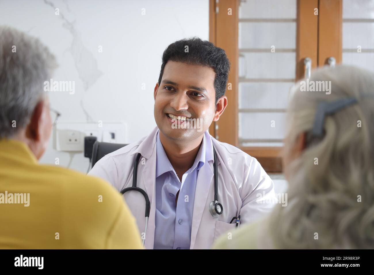 jeune médecin assis avec un patient âgé dans le salon d'une maison de retraite. Un patient âgé ayant une conversation détaillée. médecin de famille Banque D'Images