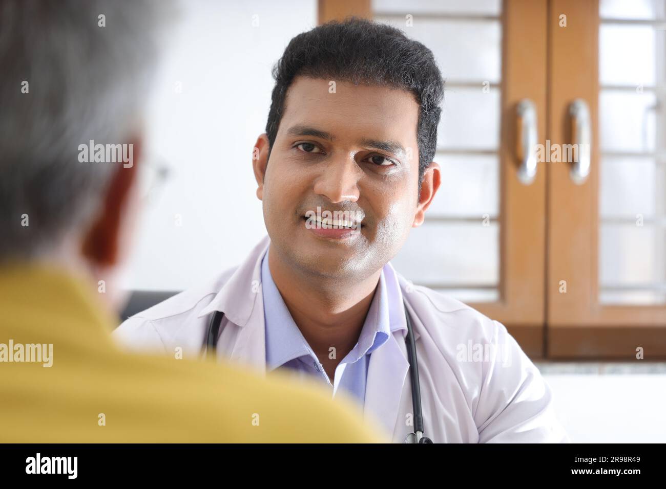 jeune médecin assis avec un patient âgé dans le salon d'une maison de retraite. Un patient âgé ayant une conversation détaillée. médecin de famille Banque D'Images