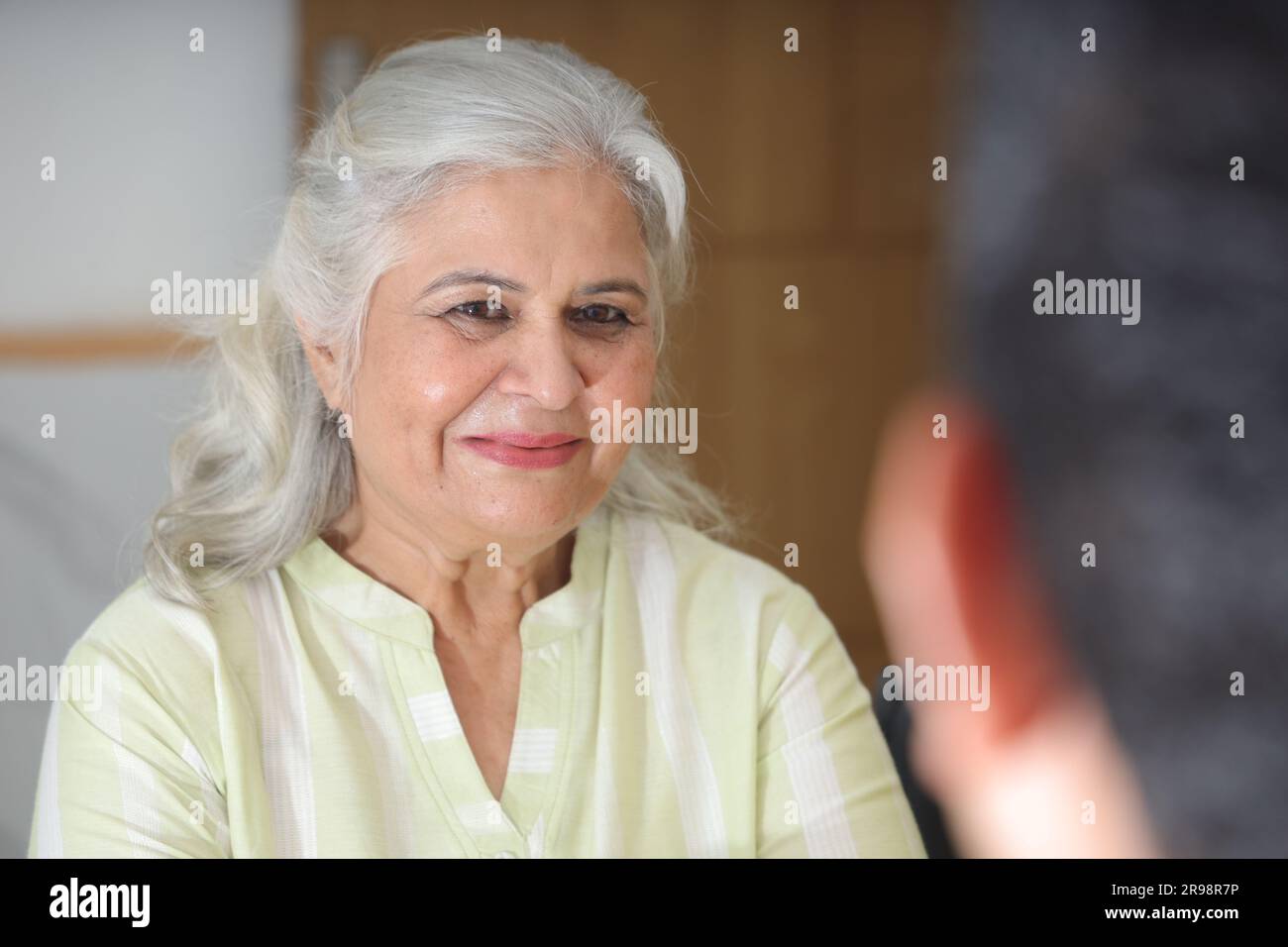 jeune médecin assis avec un patient âgé dans le salon d'une maison de retraite. Un patient âgé ayant une conversation détaillée. médecin de famille Banque D'Images