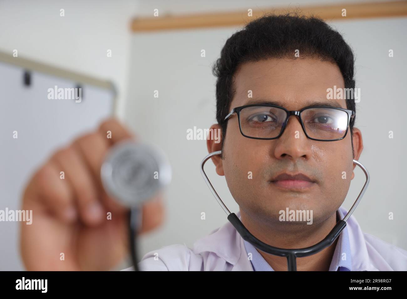 Jeune médecin indien assis avec le patient ayant une conversation détaillée. Heureux jeune docteur souriant. Concepts de services de consultation. Stéthoscope. Banque D'Images