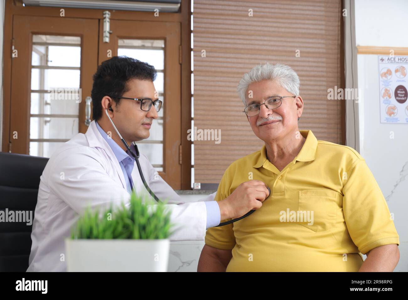 jeune médecin assis avec le patient âgé dans le cabinet du médecin. patient âgé ayant une conversation détaillée avec le médecin féminin, vérifiant la fréquence cardiaque. Banque D'Images