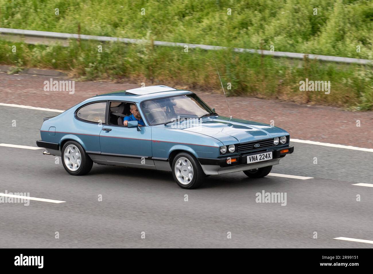 1981 80s années 80 Blue Silver Ford Capri injection, Ford Capri 2,8 injection, se déplaçant à grande vitesse sur l'autoroute M6 dans le Grand Manchester, Royaume-Uni Banque D'Images