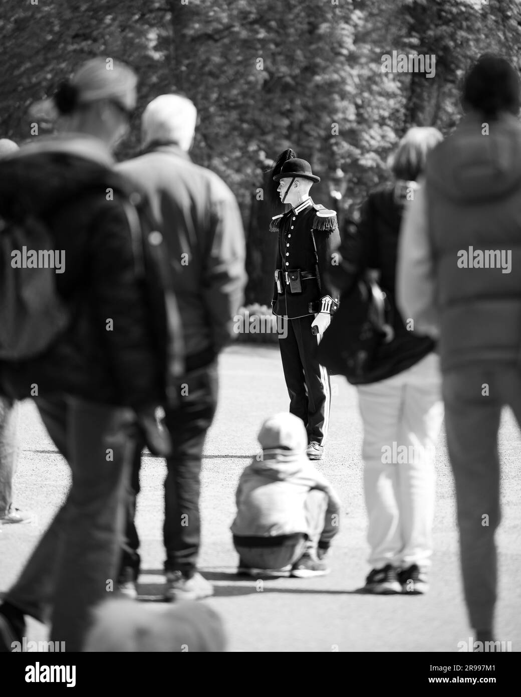 Un agent officiel de l'application de la loi veille sur un enfant dans un coin de rue urbain Banque D'Images