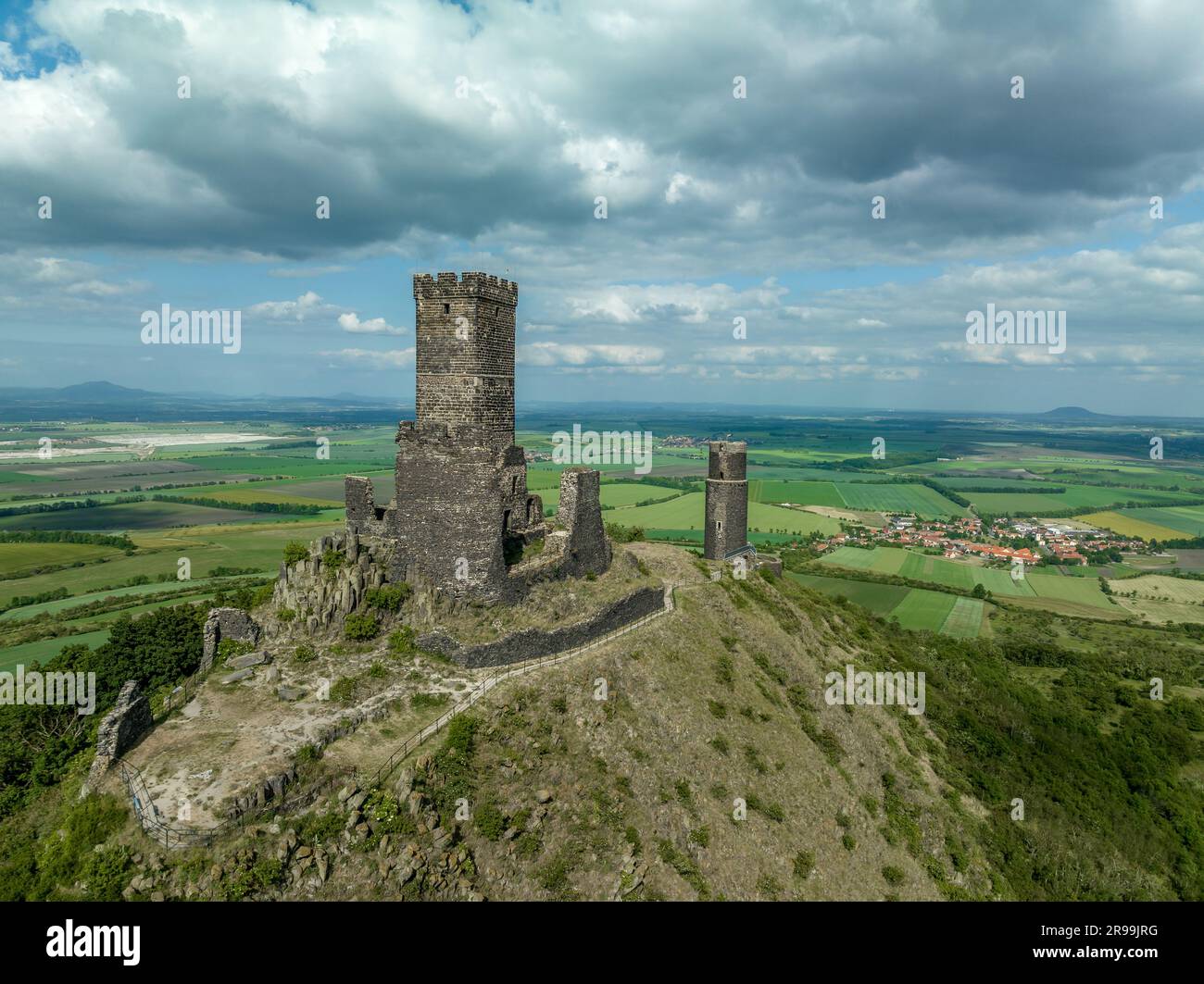 Vue aérienne sur les vestiges du château médiéval de Hazmburk avec une tour circulaire et rectangulaire, au sommet de ce lieu de randonnée bas sommet avec des paysages Banque D'Images