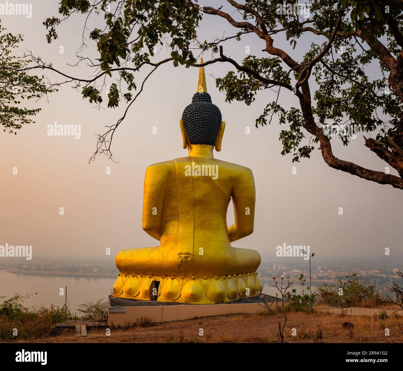 Bouddha doré surplombant Paksé au coucher du soleil. Wat Phousalao. Laos Banque D'Images