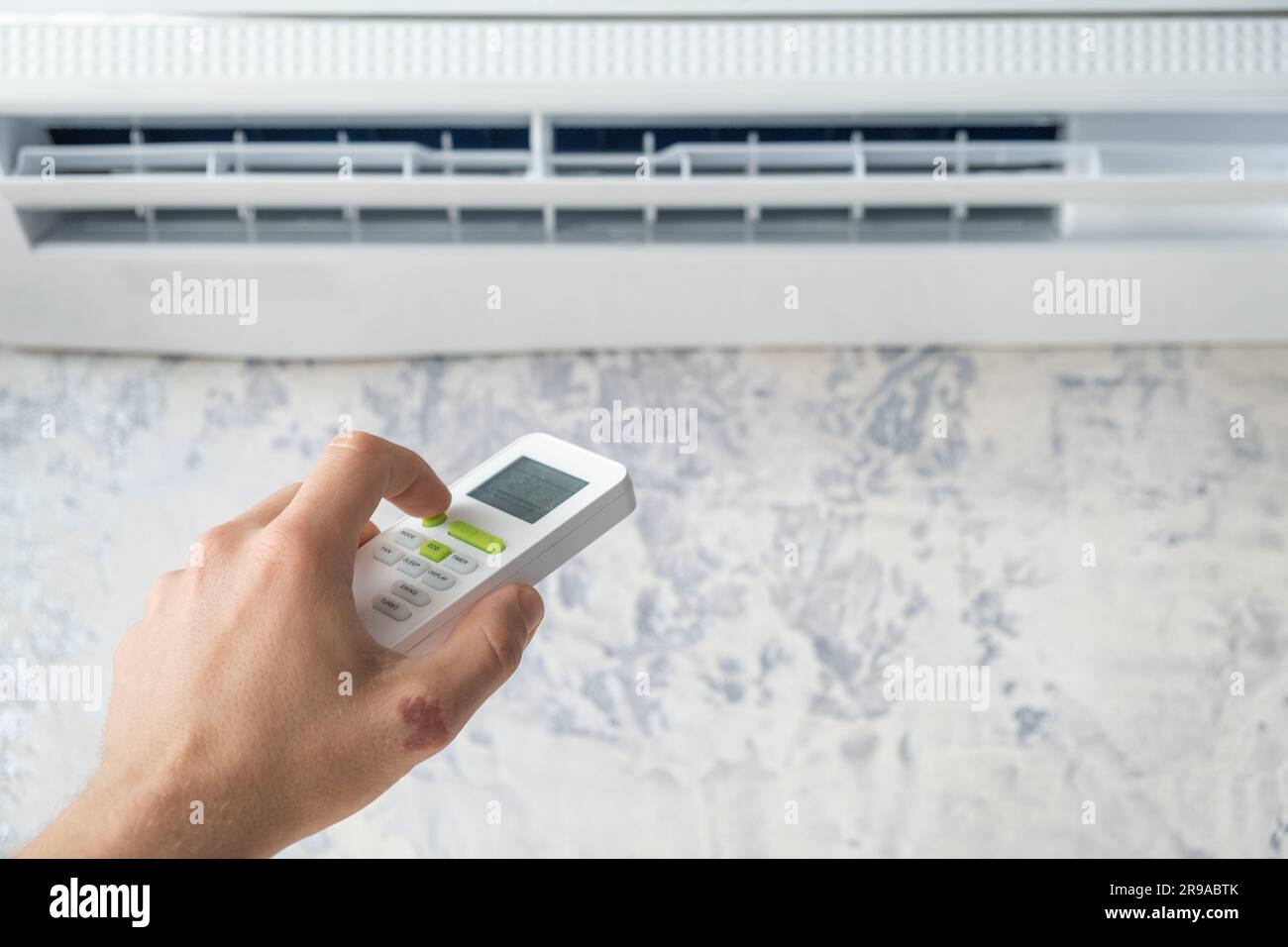 Réglage manuel de la température sur le climatiseur à l'aide de la  télécommande. L'homme allume la climatisation pour une température  confortable à la maison en été chaud Photo Stock - Alamy