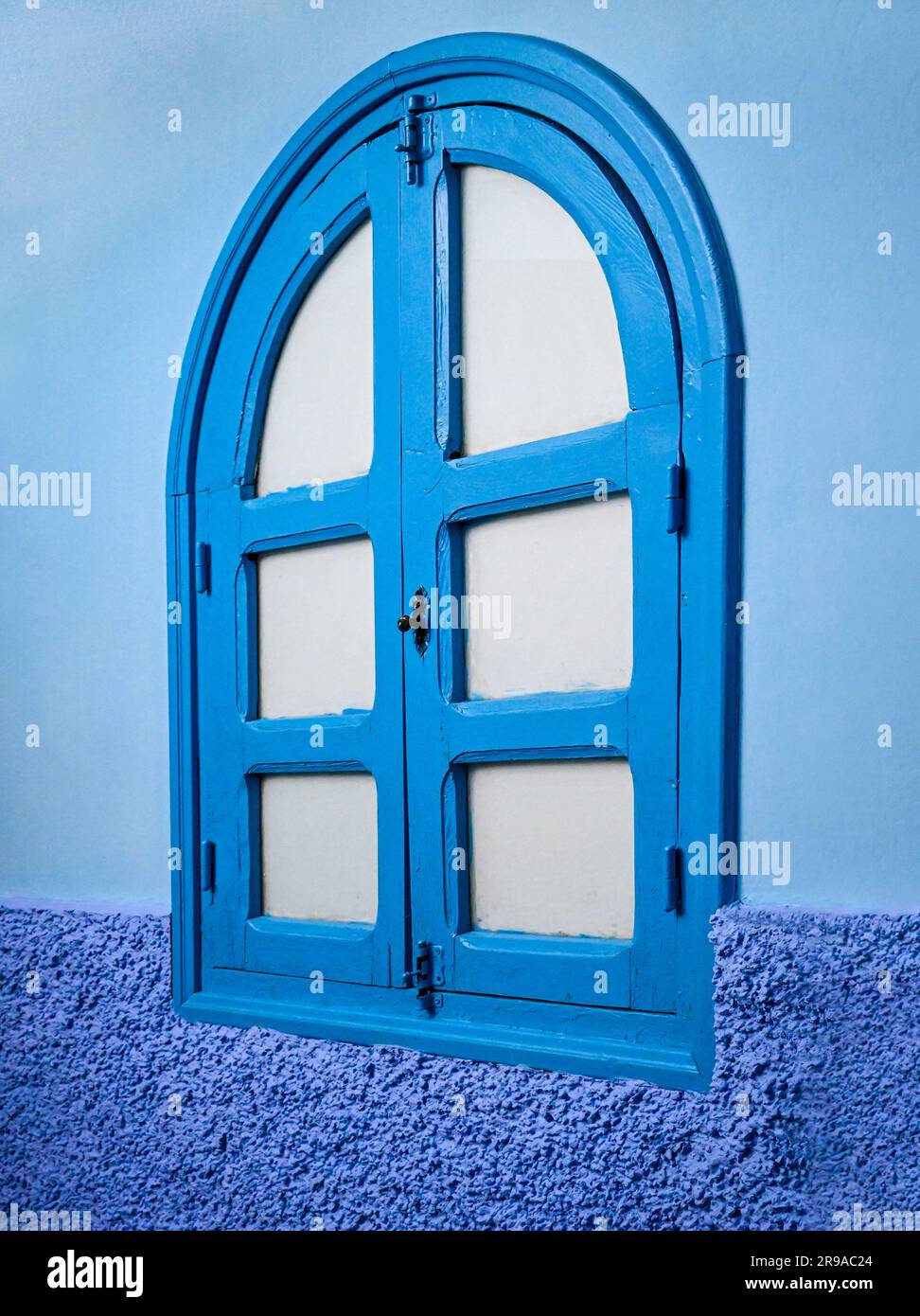 Un mur extérieur et une fenêtre en bois voûté sont dans trois tons de bleu, représentant bien la ville bleue, Chefchaouen, Maroc Banque D'Images